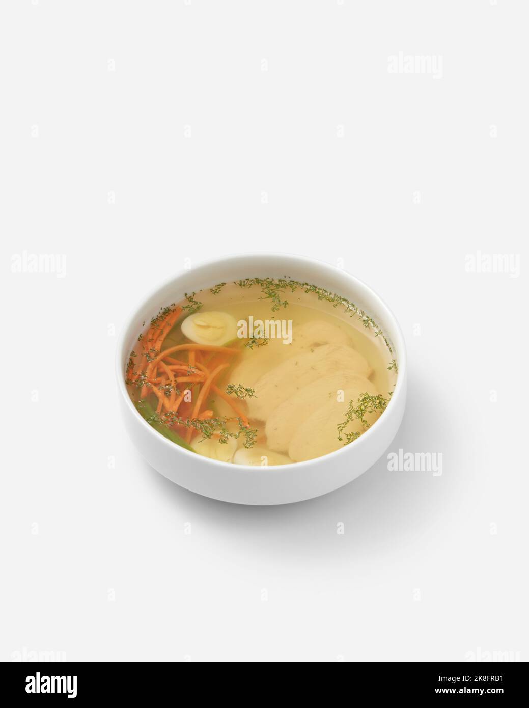 Soupe de poulet fraîche avec œufs et légumes dans un bol sur fond blanc Banque D'Images