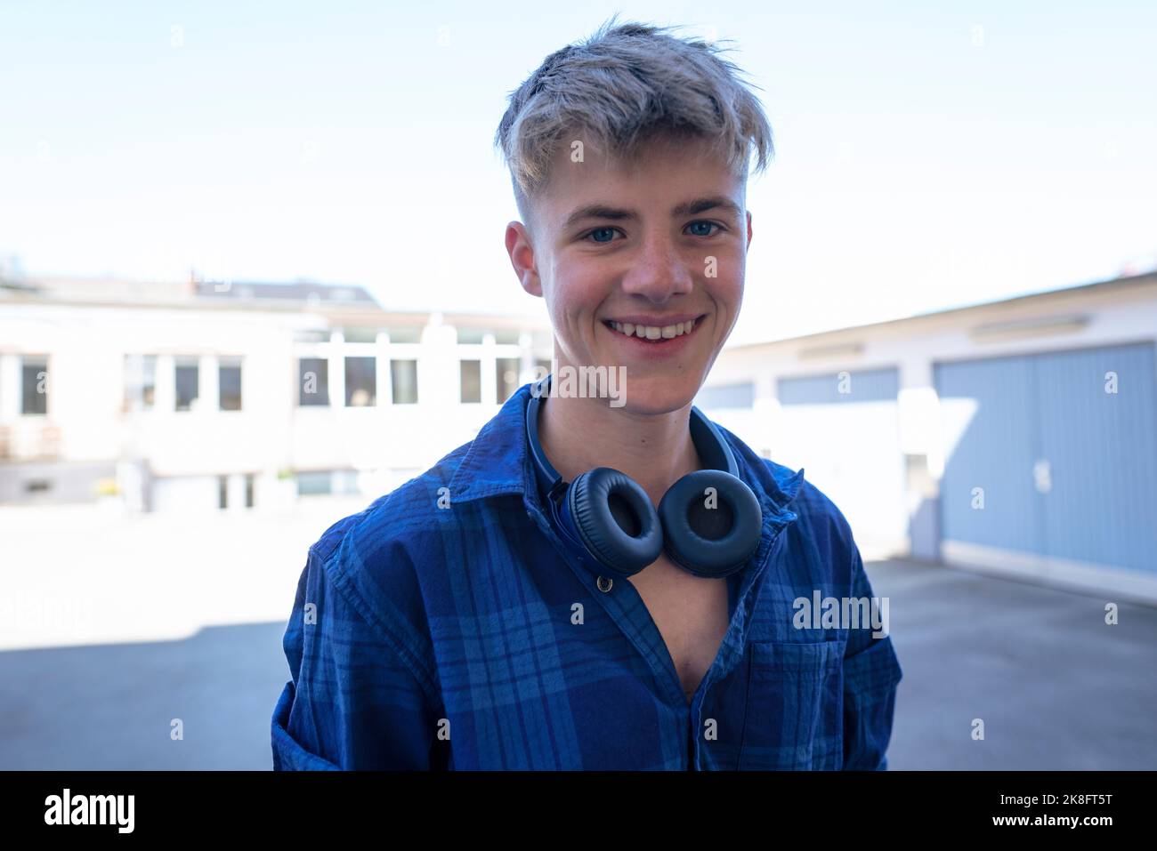 Jeune garçon souriant avec casque sans fil bluetooth Banque D'Images