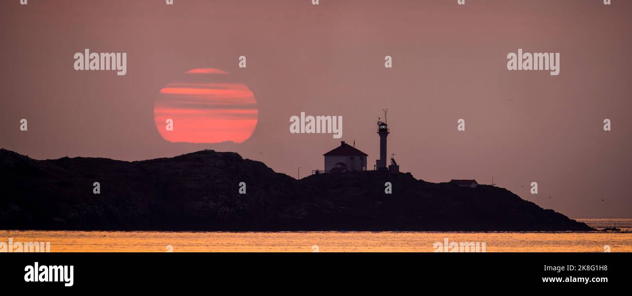 Lever de soleil au-dessus du phare des îles Trial dans le détroit Juan de Fuca près de Victoria, Colombie-Britannique, Canada. Banque D'Images