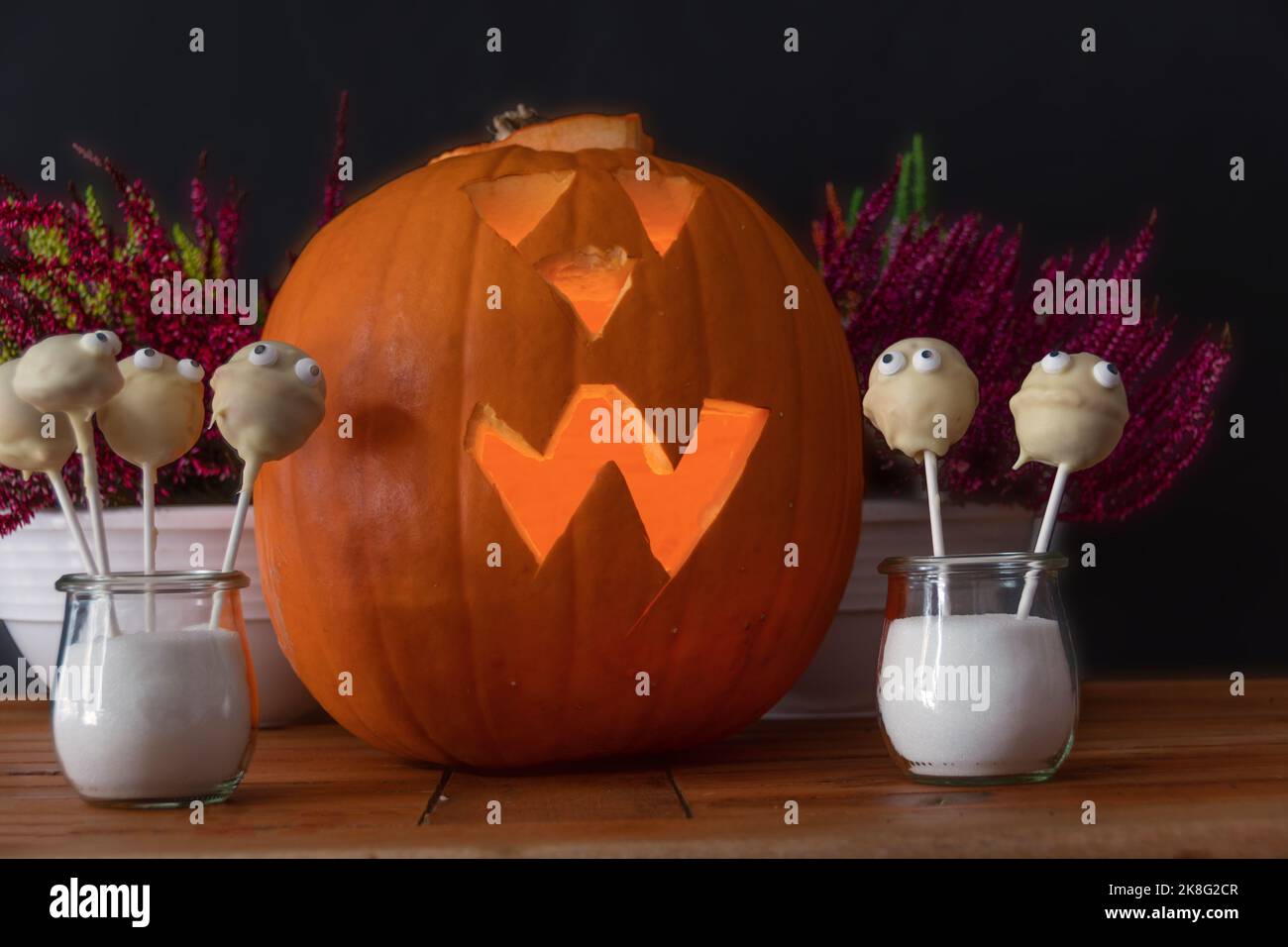Halloween mit beleuchtetem Kürbis, Pflanzen Deko und leckeren Geistern Banque D'Images
