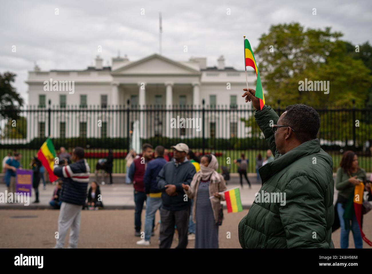 Washington, États-Unis. 23rd octobre 2022. Un manifestant fait pression sur son drapeau éthiopien devant la Maison Blanche lors d'un rassemblement pour protester contre l'intervention américaine dans la guerre en cours en Éthiopie. Une partie de la communauté DC-éthiopienne s'est réunie en face de la Maison Blanche pour protester contre l'intervention américaine dans la guerre en cours en Éthiopie (entre le gouvernement fédéral et le peuple Tigray) et contre les reportages biaisés des médias sur le conflit. Au rassemblement, les manifestants dansaient et chantaient à la musique traditionnelle éthiopienne. Crédit : SOPA Images Limited/Alamy Live News Banque D'Images