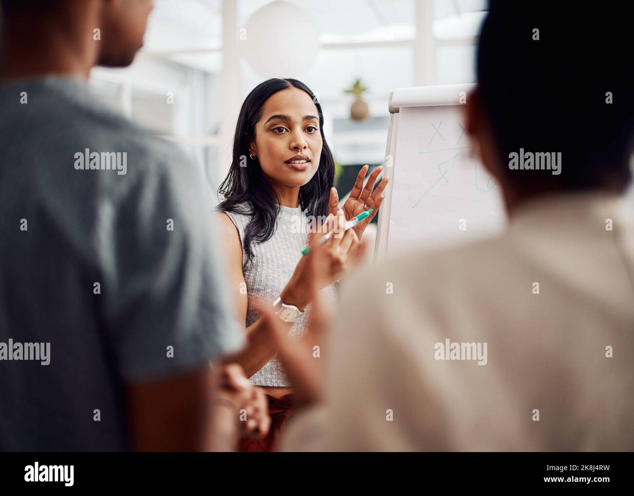 Les détails constituent une vision d'ensemble. Une jeune femme d'affaires attirante utilisant une aide visuelle pour réfléchir avec ses collègues au bureau. Banque D'Images