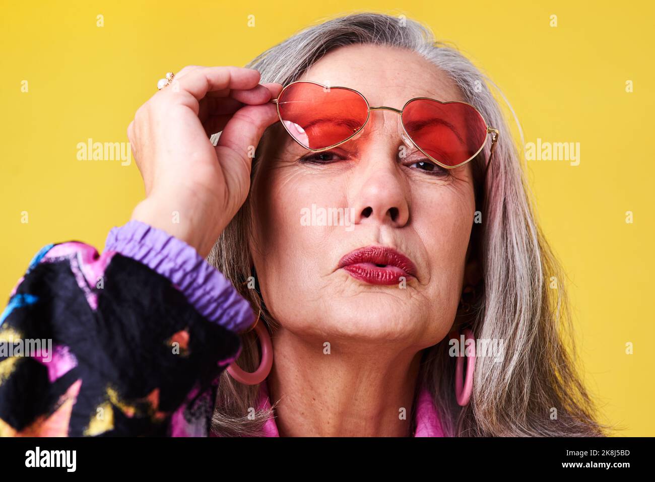 Vous devriez regarder aussi vieux que vous le sentez. Portrait d'une femme âgée confiante et élégante portant des lunettes de soleil se posant sur un fond jaune. Banque D'Images