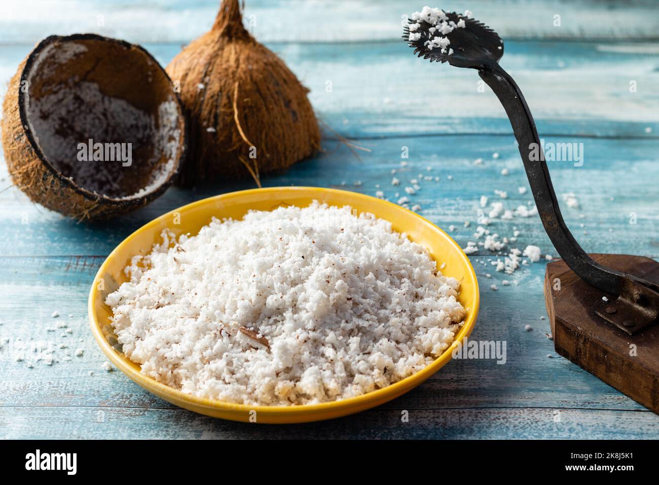 Les coquilles et le sol avec un grattoir sur une table en bois bleu Banque D'Images