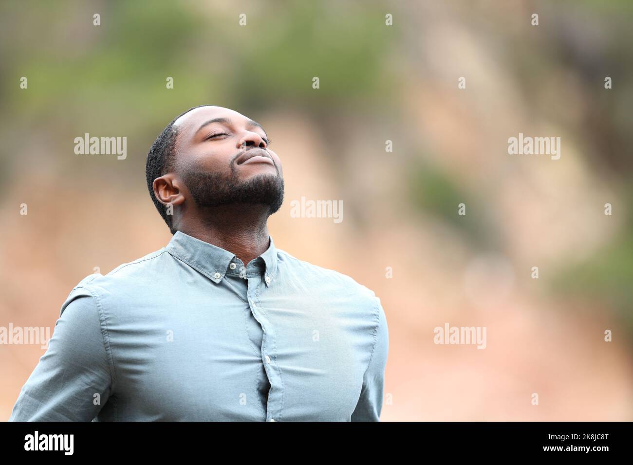 Homme noir relaxant respirant de l'air frais à l'extérieur Banque D'Images