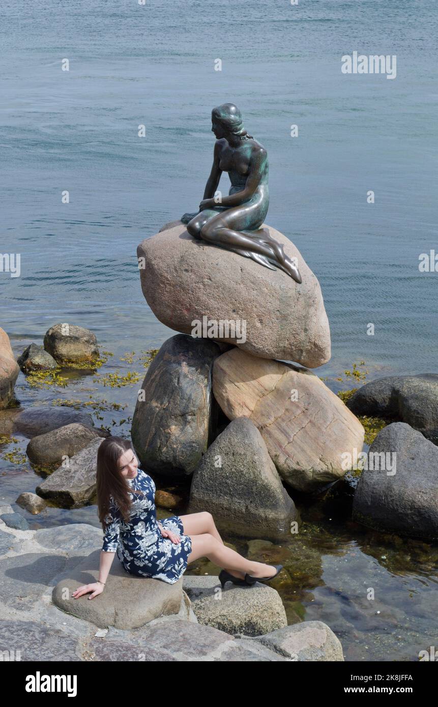 Fille pose pour une photo devant la statue de la petite Sirène sur le front de mer, Copenhague, Danemark Banque D'Images