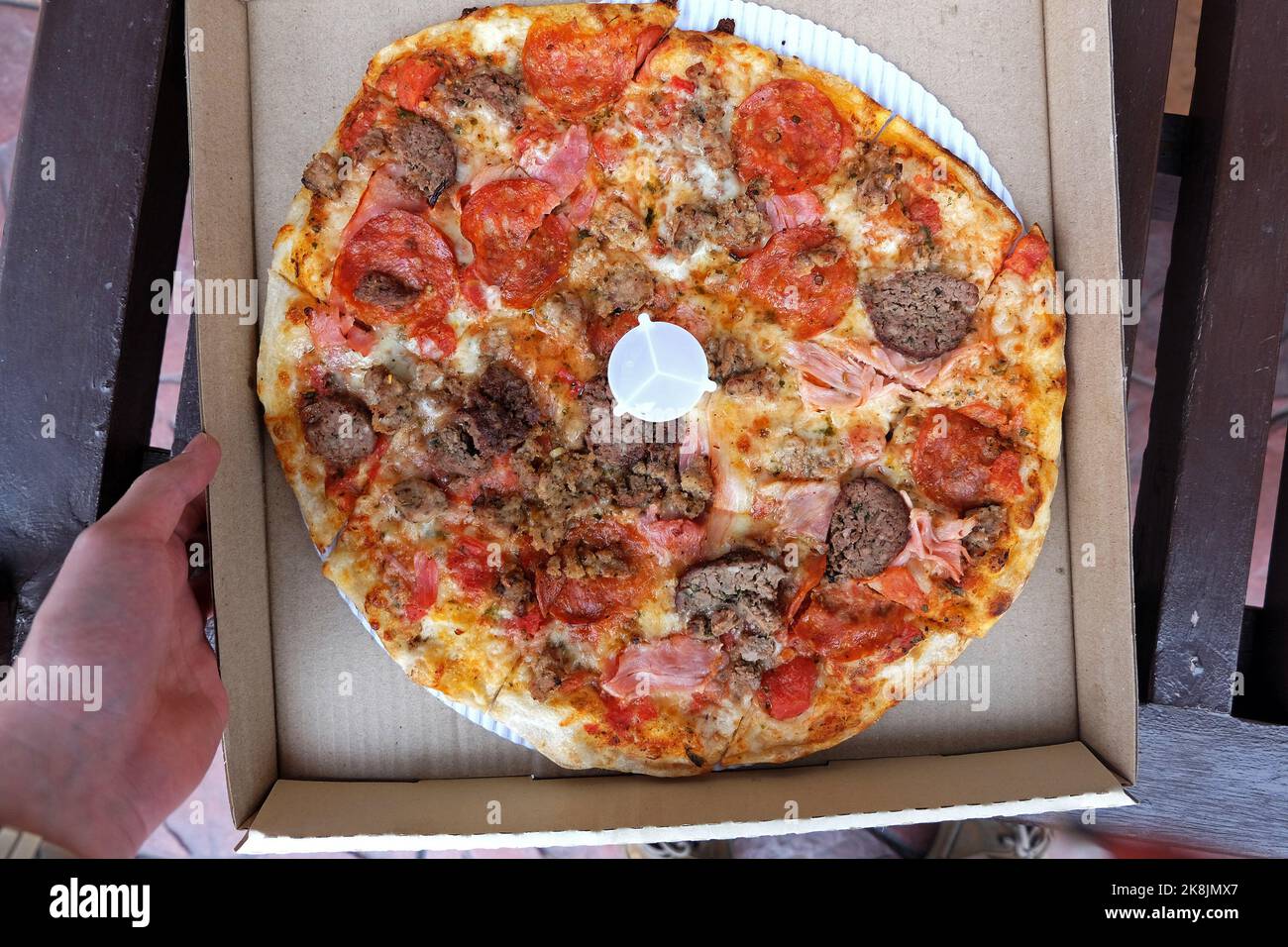 Fermer la boîte de pizza à croûte mince recouverte de poivre de jambon et de saucisses Banque D'Images