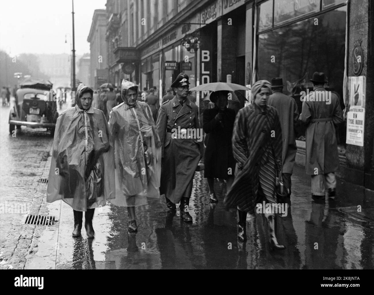 Oslo 19411015. La vie populaire à Karl Johansgate à Oslo Un jour pluvieux pendant la guerre, 15 octobre 1941. Au milieu des piétons avec parasols et vêtements de pluie un soldat de Turk (officier) en uniforme. Photo: Aage Kihle / NTB Banque D'Images