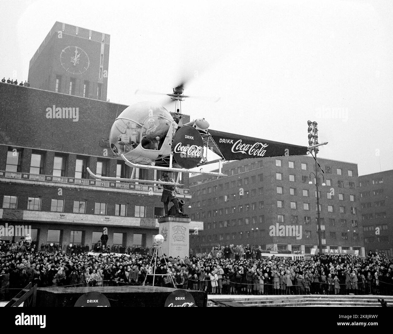 Jeux olympiques d'hiver d'Oslo 1952. Pendant les Jeux Olympiques, Coca Cola a eu une grande campagne publicitaire. Dans la photo, nous voyons un hélicoptère avec la publicité Coca Cola qui atterrit devant la mairie. Banque D'Images