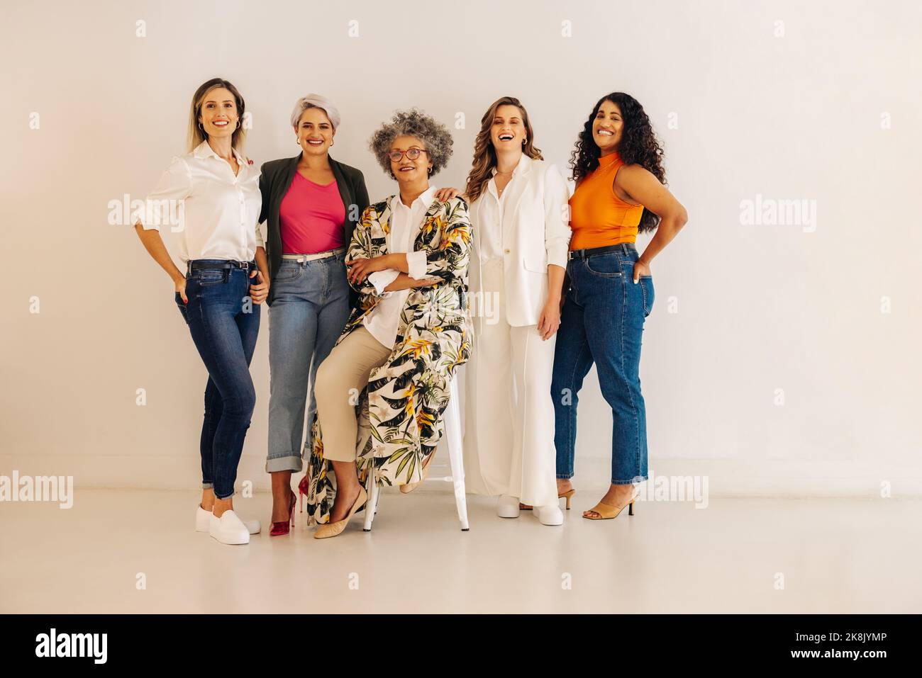 Démarrage de toutes les femmes réussi. Diverses femmes entrepreneurs souriant à la caméra tout en se tenant ensemble contre un mur. Groupe de bussin multiculturel Banque D'Images