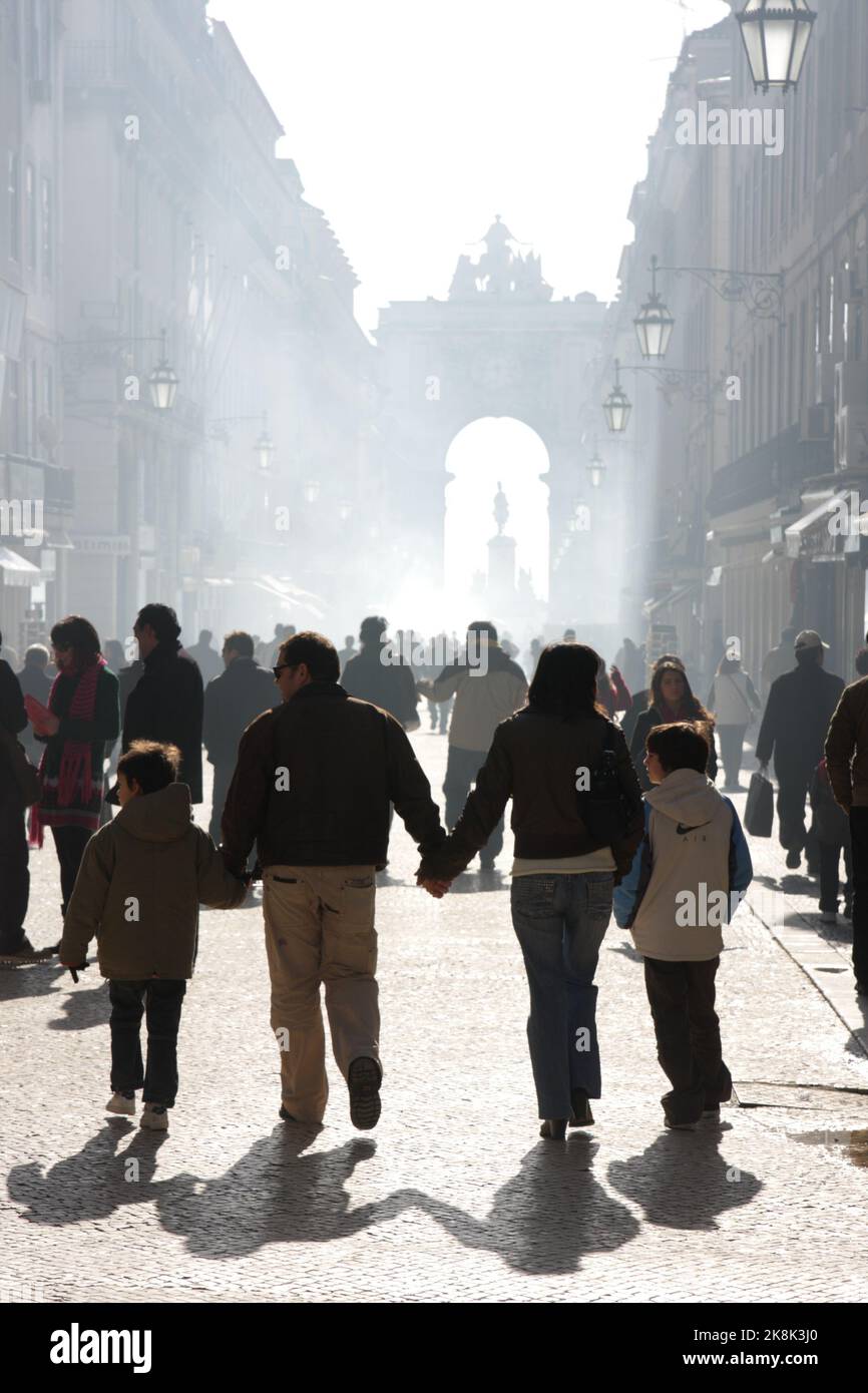 Personnes marchant sur la Rua Augusta, Rua Augusta Arch au loin, lors d'une journée d'hiver brumeuse, Lisbonne, Portugal Banque D'Images