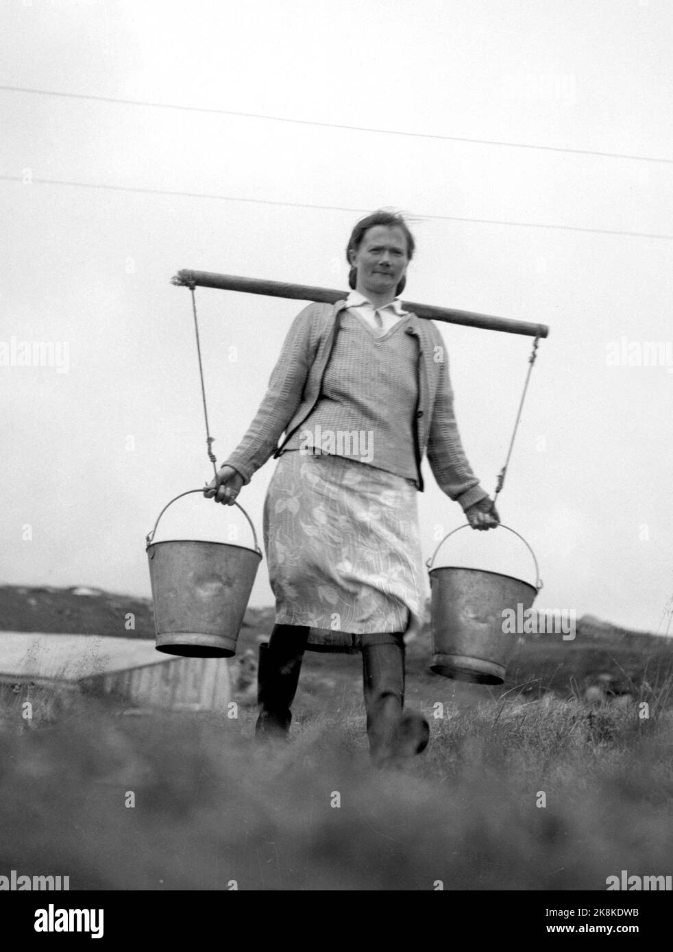 Sørøya dans le Finnmark au printemps de 1947, la plupart de la population de Sørøya était sur 15 février 1945, évacué en Écosse par British / Allied Marine, après avoir vécu dans des casernes et des grottes de montagne sur la course des Allemands. Aujourd'hui, la population de Sørøya est aux prises avec la reprise. Ici Mme Elida Olsen de Dønnesfjord, qui doit transporter toute l'eau à la maison à plus de 200 mètres. Photo : Th. Scotaam / courant / NTB. Banque D'Images