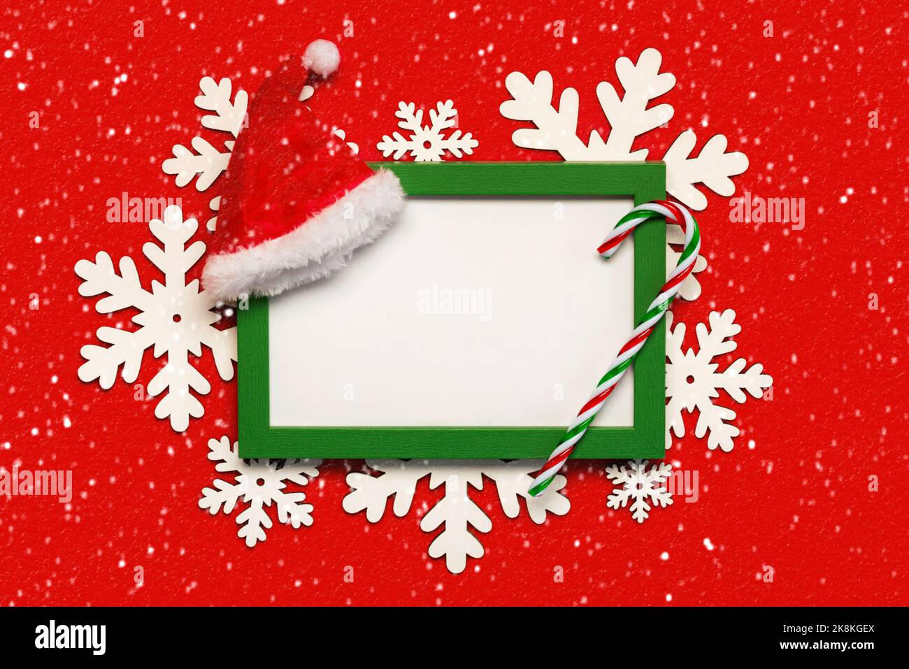 Joyeux Noël. Cadre vert avec espace de copie blanc, décoration de Noël et flocons de neige sur fond rouge. Arrière-plan du concept de Noël Banque D'Images