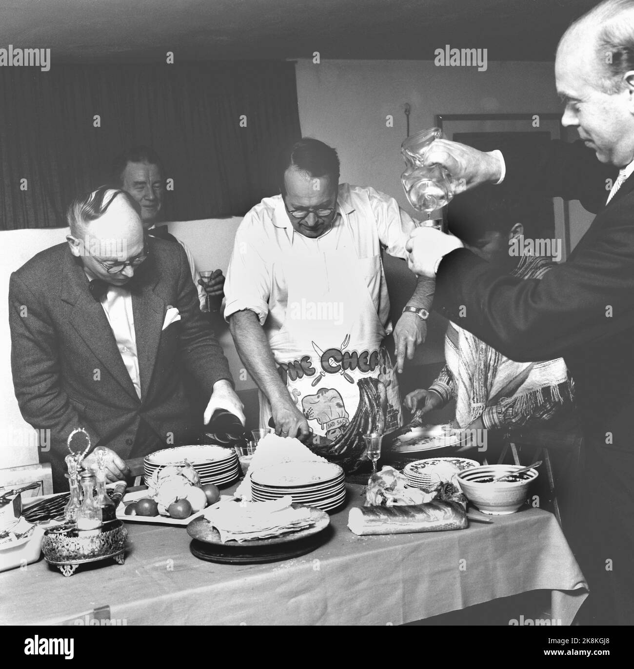 Noël Oslo 1958. Les membres Prominated de 'Press's Lutlag' ont composé une table de Noël très inhabituelle. Chaque homme a même fait le droit qu'il préférerait. La table de Noël a été agencée à la Ligjordet de la famille Leif Borthen. Ici, le moment approche de l'auteur Odd Bang-Hansen fours vin rouge et journaliste Torgny l'article traite la bouteille de clinking. Photo: Aage Storløkken Current / NTB Banque D'Images