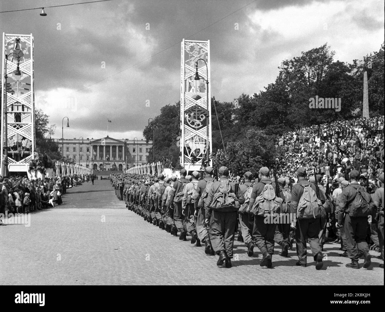 Oslo 19450609 Journées de la paix 1945. Accueil le jour de la réception. Le front de mer de Karl Johans part en direction du château et est rejeté par de grandes foules. Voici une compagnie de soldats à la maison avec des sacs à dos sur le chemin jusqu'au château. Les décorations de la place au retour du roi décorent encore la rue. Photo: NTB / NTB Banque D'Images