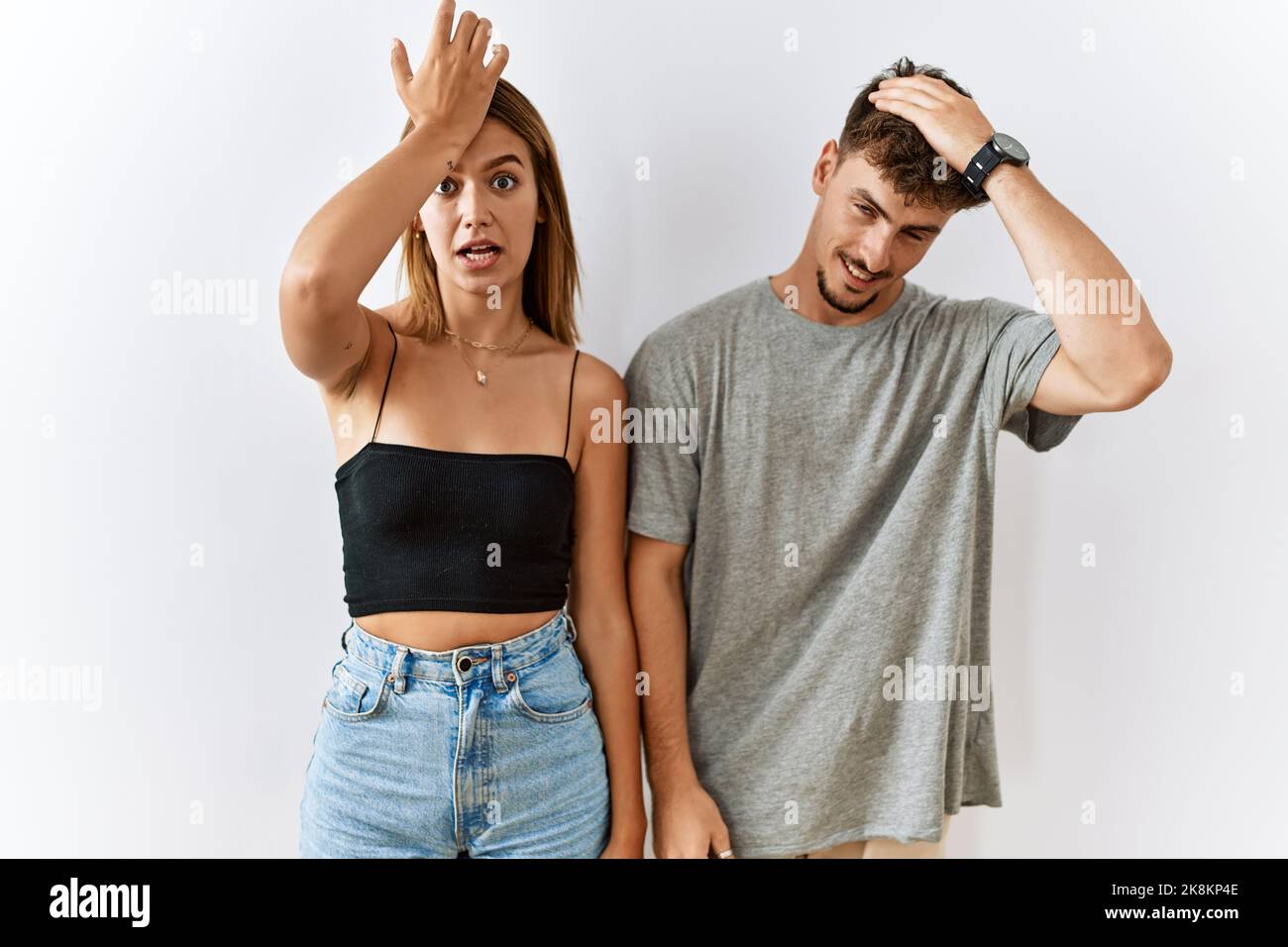 Jeune beau couple debout ensemble sur un fond isolé surpris par la main sur la tête pour l'erreur, rappelez-vous l'erreur. oublié, mauvais concept de mémoire. Banque D'Images Jeune beau couple debout ensemble sur un fond isolé surpris par la main sur la tête pour l'erreur, rappelez-vous l'erreur. oublié, mauvais concept de mémoire. Banque D'Images