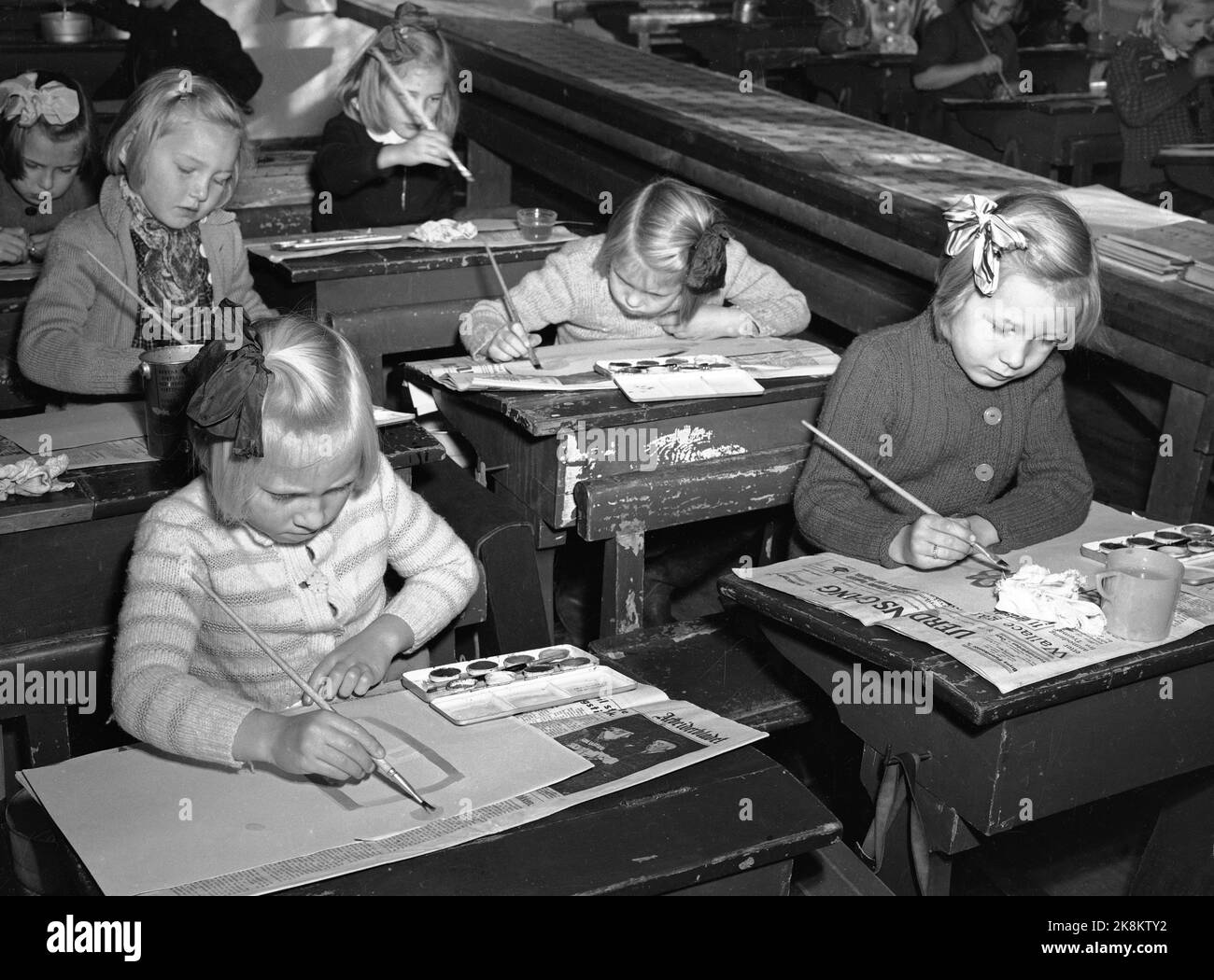 Oslo 19470111 Par jour à l'école Bjølsen. Concours national pour les enfants dans les écoles primaires norvégiennes. Photos de l'environnement de l'école Bjølsen. Les filles avec des boucles dans leurs cheveux s'assoient sur leur bureau. Dessine. Concentré. Photo: Actuel / NTB NB !! L'image n'est pas traitée !! Banque D'Images