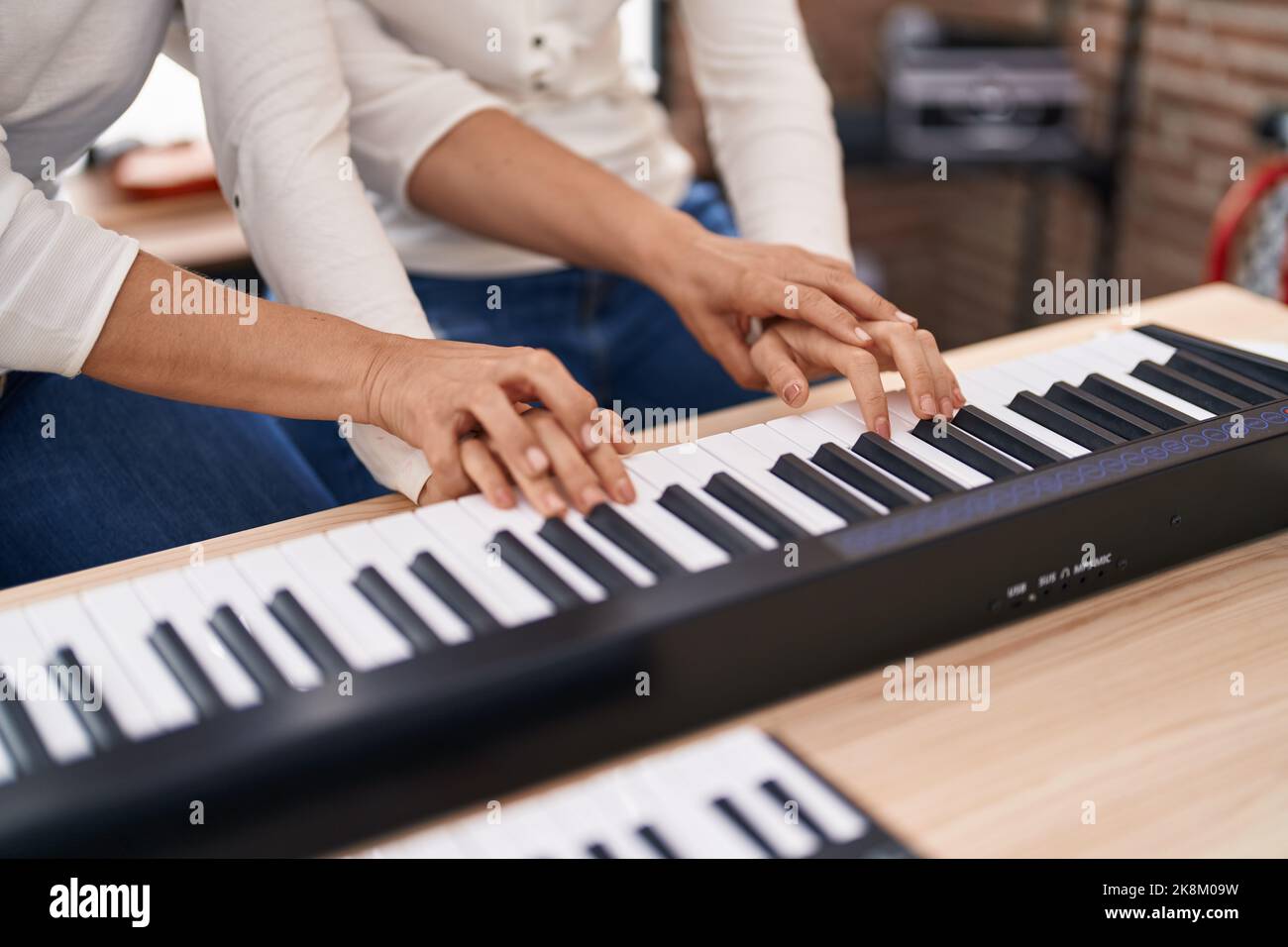 Deux femmes musiciens ayant cours de piano au studio de musique Banque D'Images