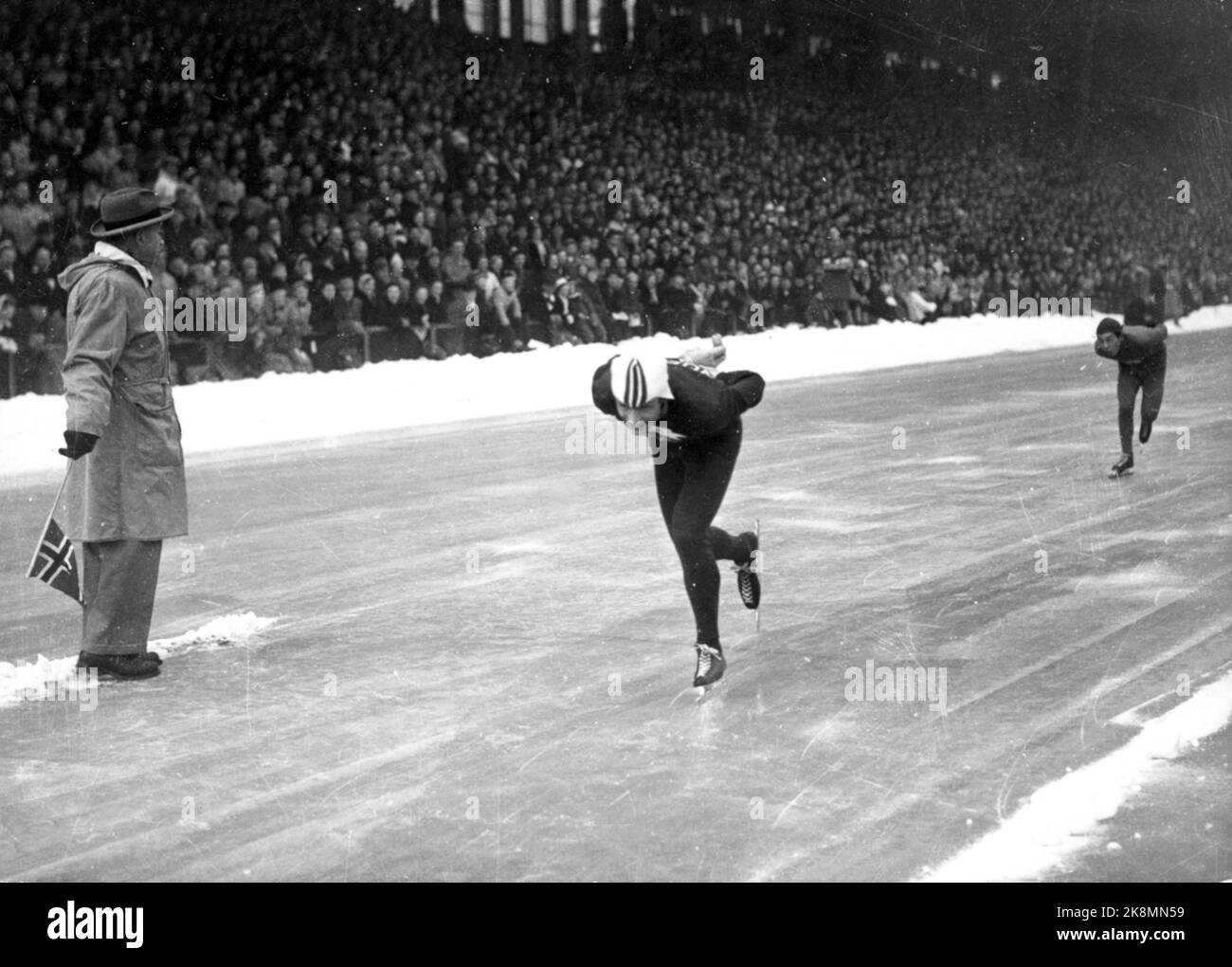 19520219 Oslo: Jeux Olympiques, Jeux Olympiques d'hiver, Patinage, course rapide, 10 000 mètres: Le gagnant Hjalmar Andersen 'Hjallis' (TV) en action. Il vient de passer son compagnon de parc Kazuhiko Sugawara (JPN) avec un tour. Droit à V : l'échange indique avec des drapeaux. Photo: NTB / NTB Banque D'Images