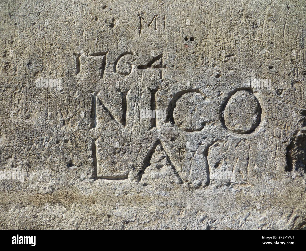'1764 Nicolas' au 11 place des Vosges, à Paris, dans le quartier du Marais, sur l'un des piliers de ses célèbres arcades, on peut voir ce qui est considéré comme l'un des plus anciens graffitis de Paris. Sur ce graffiti daté de 1764 et gravé dans la pierre (qui l'a certainement permis d'être conservé jusqu'à aujourd'hui), on peut lire le premier nom 'NICOLAS' qui en est l'auteur, Nicolas Edme Restif de la Breton, un écrivain. Il les a créés dans tout Paris et les a publiés dans son livre "mes inscriptions". Seul celui sur la place des Vosges reste aujourd'hui Banque D'Images