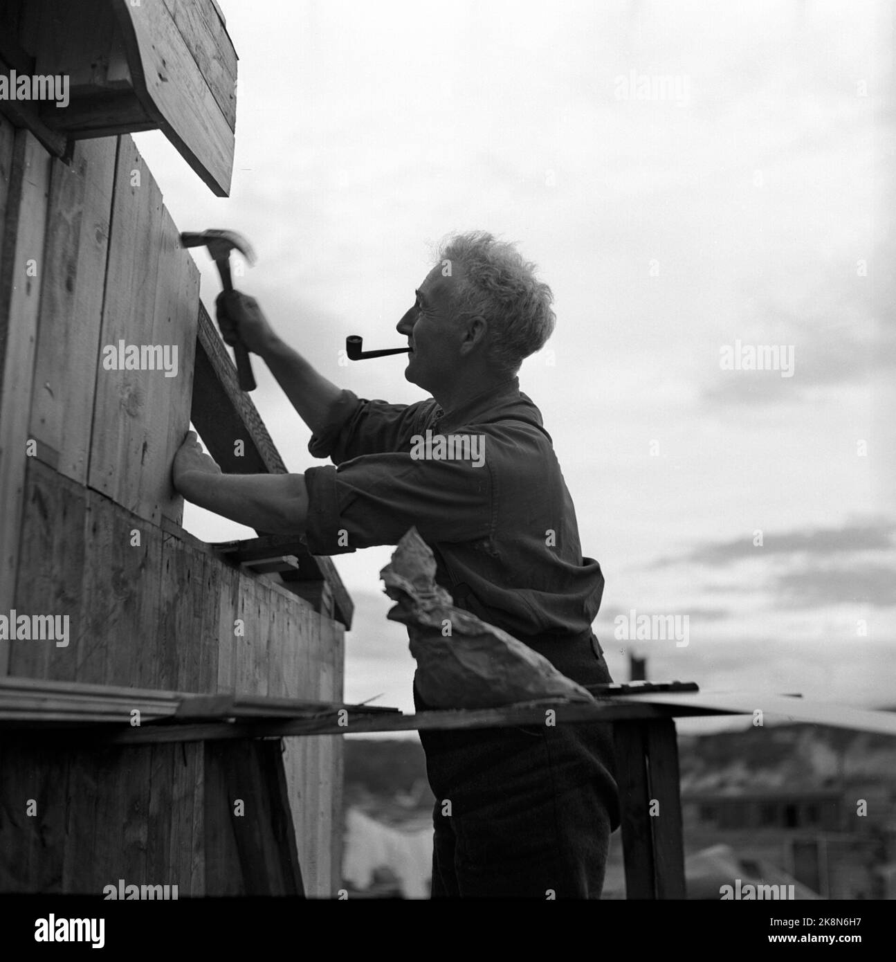 Le 1946 septembre, l'Église a récupéré dans le nord de la Norvège après la Seconde Guerre mondiale Construction de logements. Les personnes privées travaillent avec leurs propres maisons. Homme qui se tient sur une échelle avec un marteau et des ongles sur sa propre maison. Photo: NTB / NTB Banque D'Images