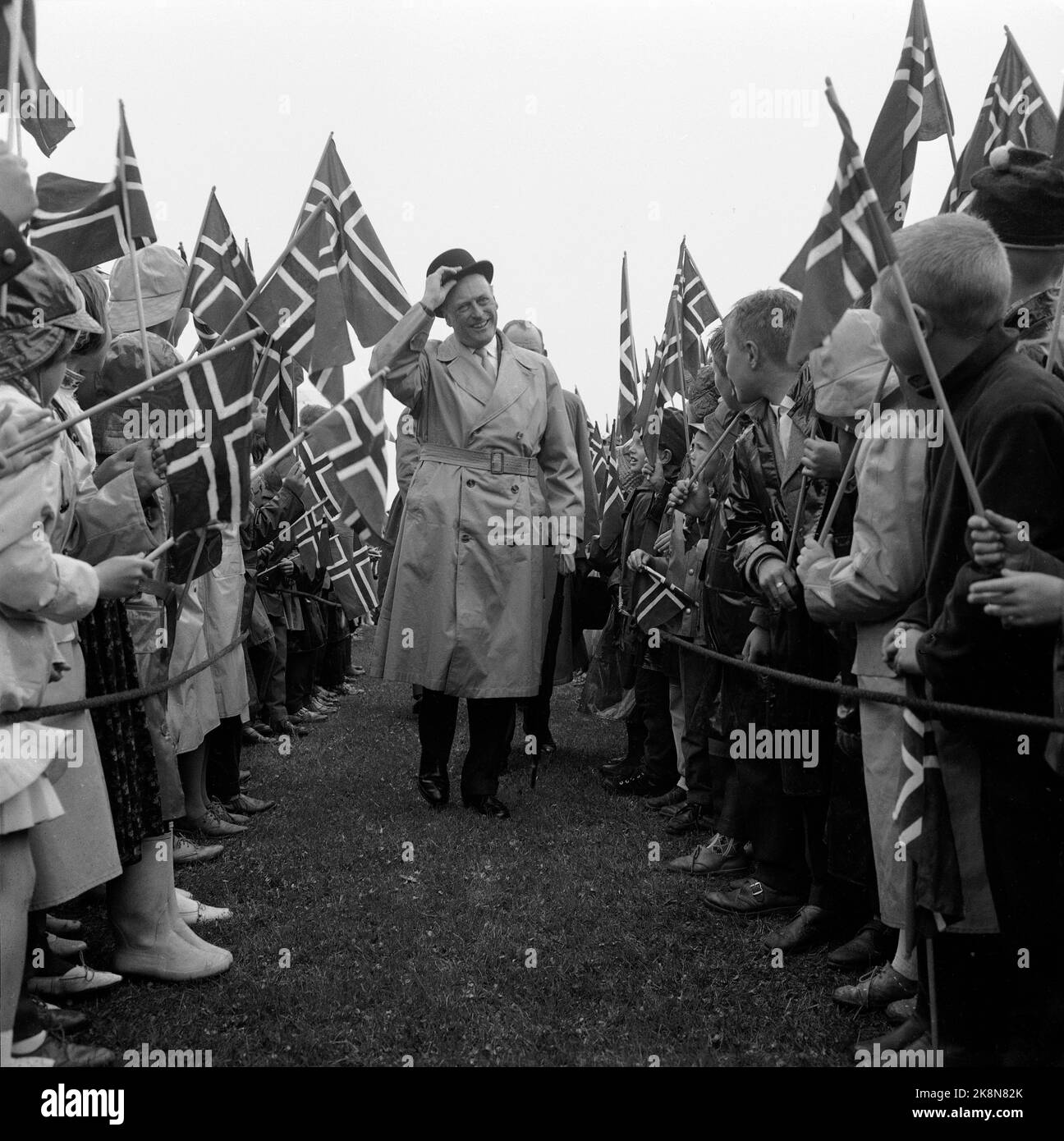 Eidsvoll 19620213 le dévoilement du monument du peuple norvégien au poète Henrik Wergeland devant le bâtiment Eidsvoll. Ici, le roi Olav arrive au dévoilement, et est accueilli par des enfants heureux avec des drapeaux. Un peu de pluie ne semble pas mettre un amortisseur sur l'humeur. Photo: NTB / NTB Banque D'Images