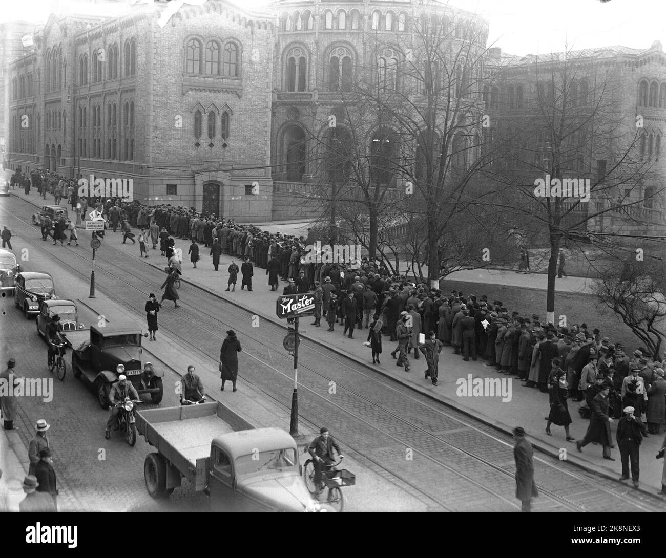 Oslo 19400406: Le ministre des Affaires étrangères Halvdan Koht s'adressera aux représentants parlementaires, et en dehors du Storting, il y a une file d'attente le long de toute la porte Karl Johans de particuliers qui veulent entrer et écouter la déclaration du ministre des Affaires étrangères. Le discours a eu lieu trois jours avant le début de la guerre. (Affiche publicitaire pour le maître bleu de cigarette en premier plan) photo: NTB Banque D'Images