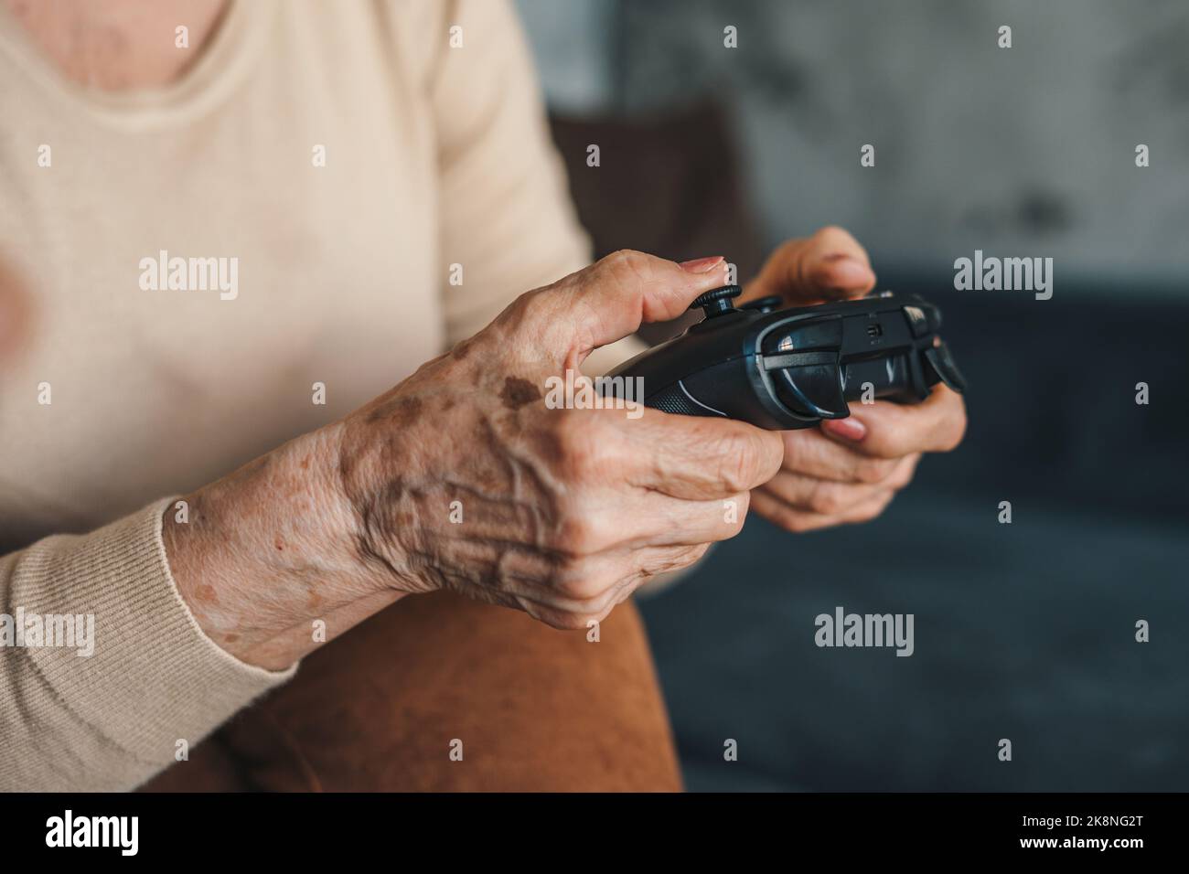 Gros plan portrait des mains d'une femme âgée tenant un joystick passant son temps intéressant à jouer à des jeux vidéo d'ordinateur. Télécommande pour Banque D'Images
