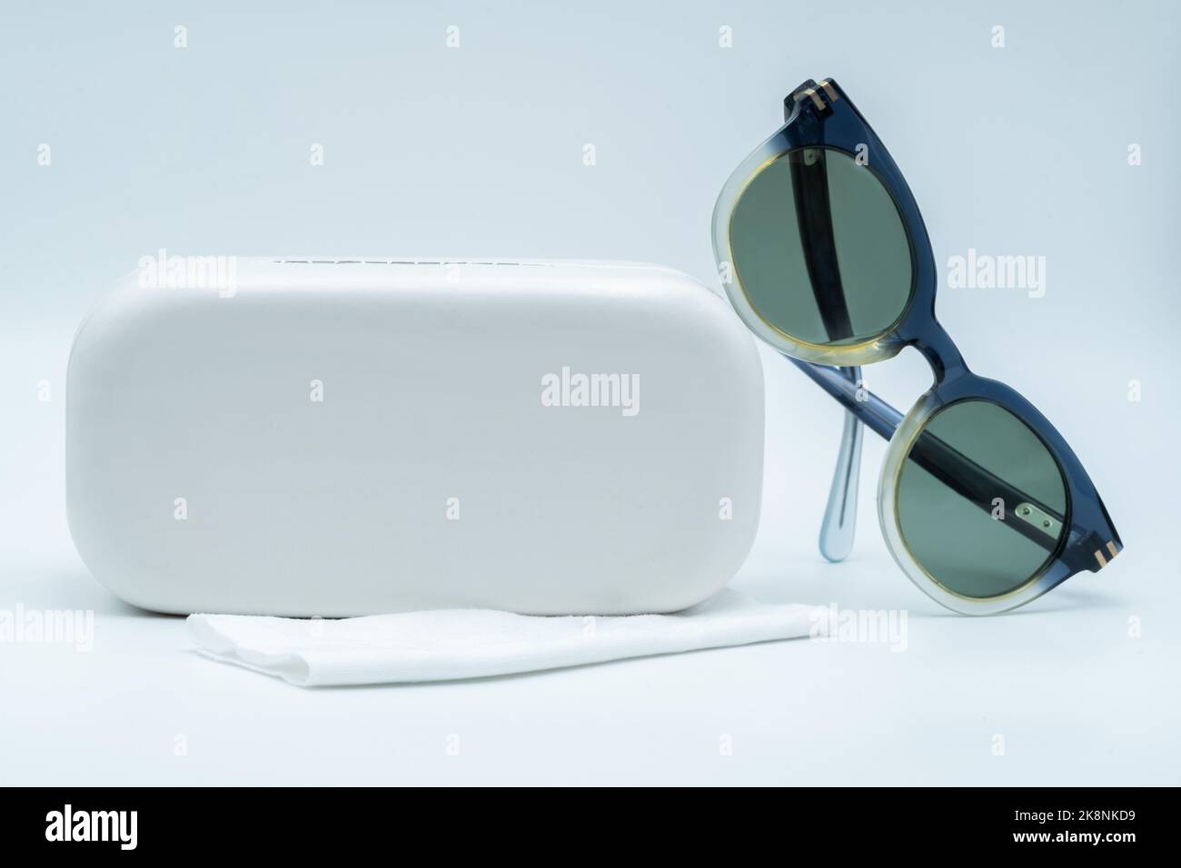 Les lunettes de soleil avec son étui blanc sur fond blanc. Banque D'Images