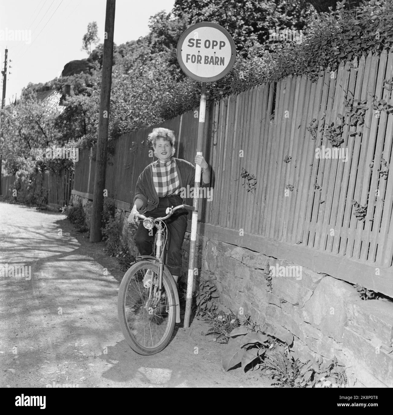 Kragerø 195406 - photos d'été de Kragerø. Jeune femme avec vélo à côté des panneaux de signalisation. « Attention aux enfants ». Photo: Actuel / NTB Banque D'Images