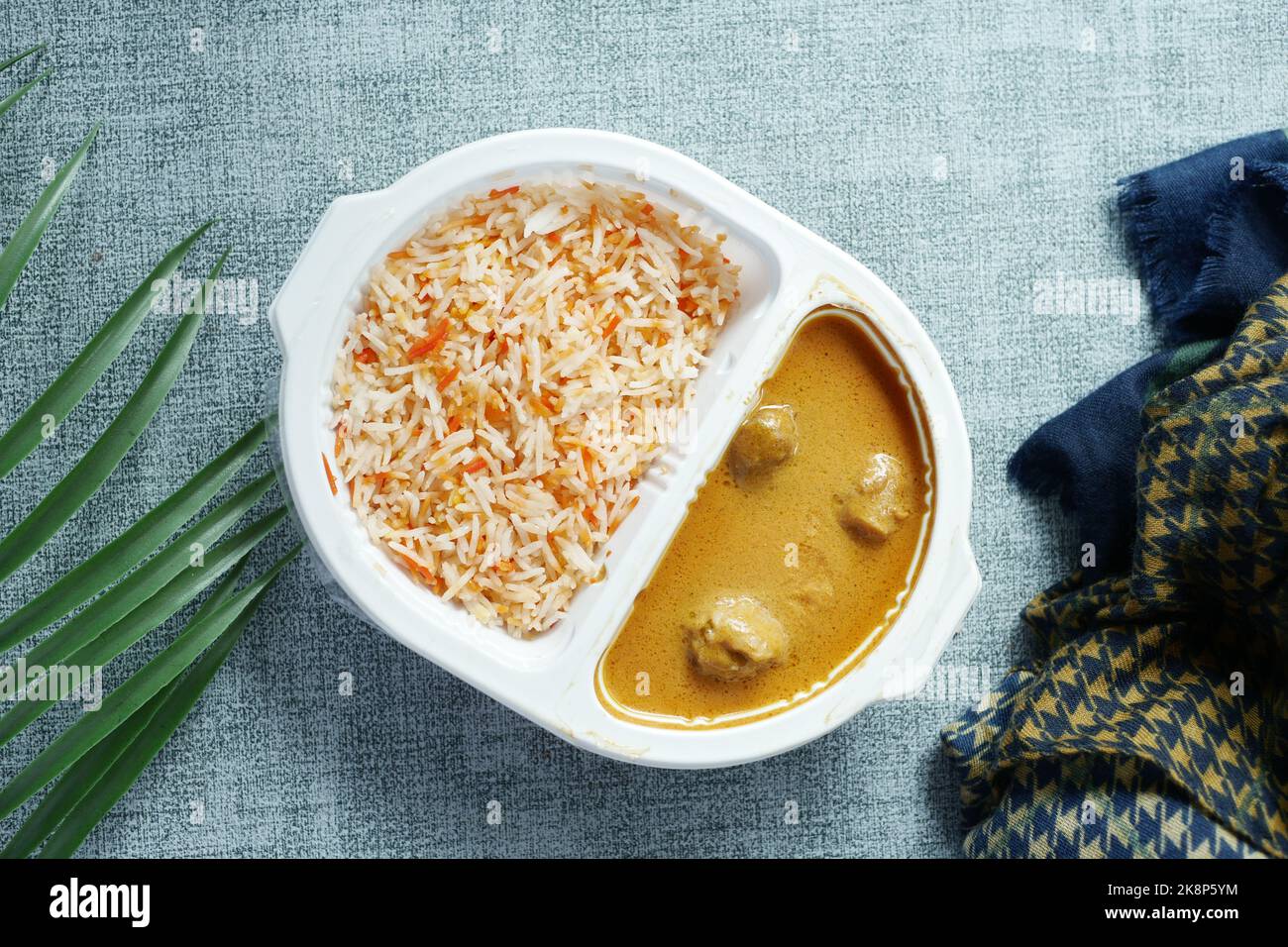 curry de poulet et de riz dans un sachet en plastique à emporter sur la table Banque D'Images