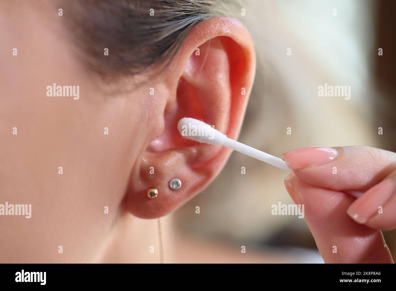 Femme nettoyant les oreilles et utilisant un coton-tige Banque D'Images