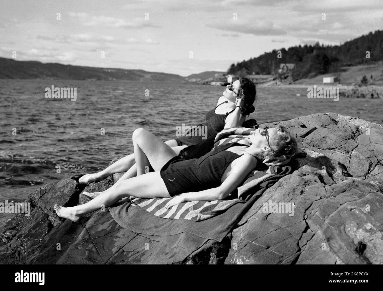 Oslo 19490414 un couvercle de Pâques exceptionnellement chaud beaucoup pour les bains de soleil. Ici, deux femmes qui prennent le soleil dans des maillots de bain sur une montagne rocheuse sur le fjord d'Oslo. Photo: NTB / NTB Banque D'Images