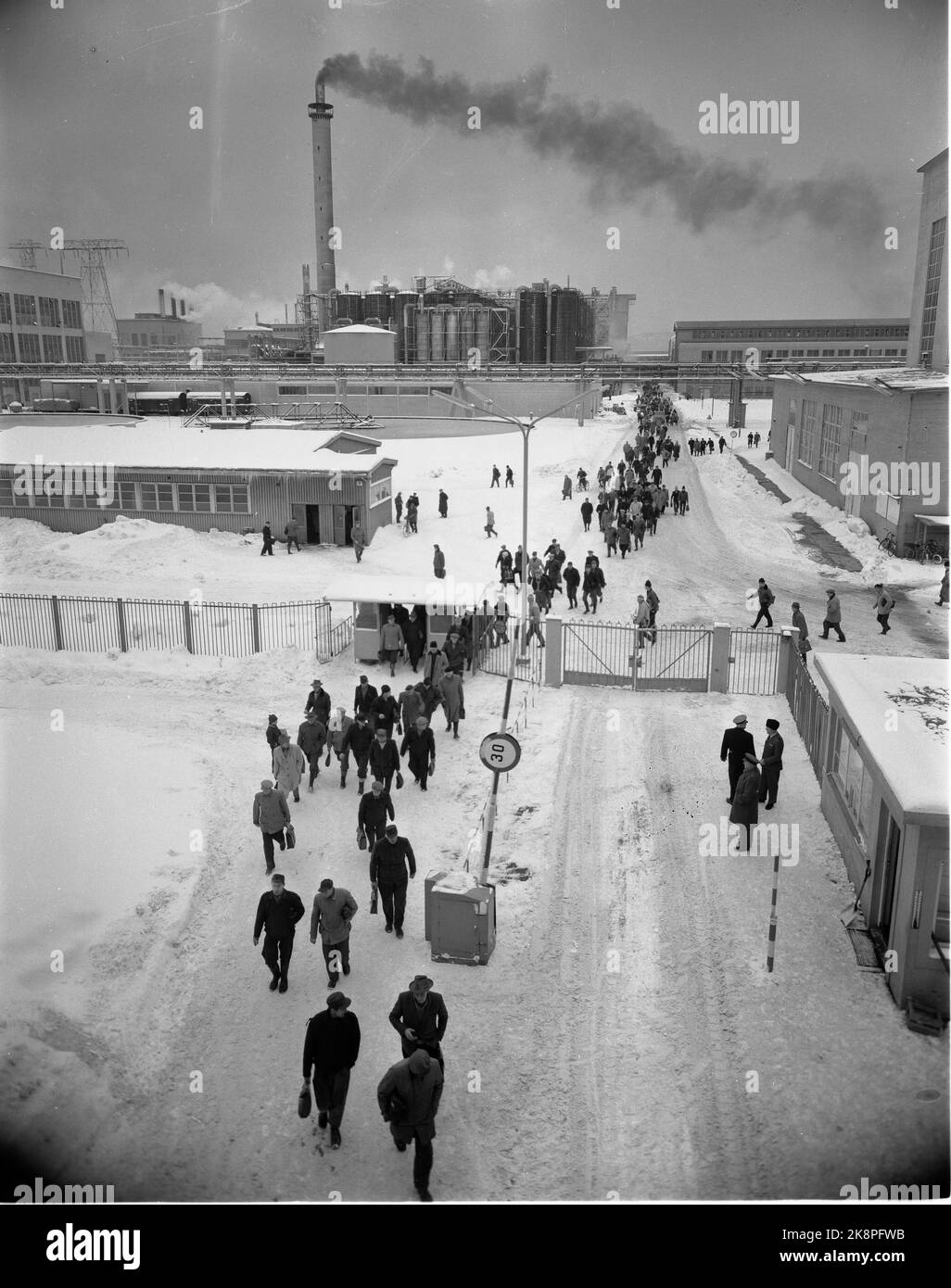 Herøya 196010. L'usine de Norsk Hydro sur Herøya, extérieur. Les travailleurs partent du quart de travail. L'usine en arrière-plan, fumée de la pipe. Usines. Photo: Aage Storløkken / actuel / NTB Banque D'Images