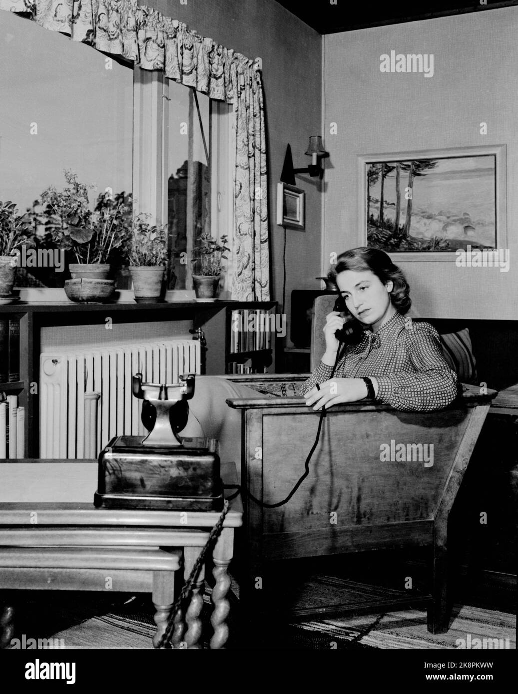 Oslo194702 la Norvège a établi une connexion téléphonique avec les États-Unis: Voici une illustration. Intérieur d'un salon avec une femme sérieuse parlant au téléphone. Photo: NTB / NTB Banque D'Images