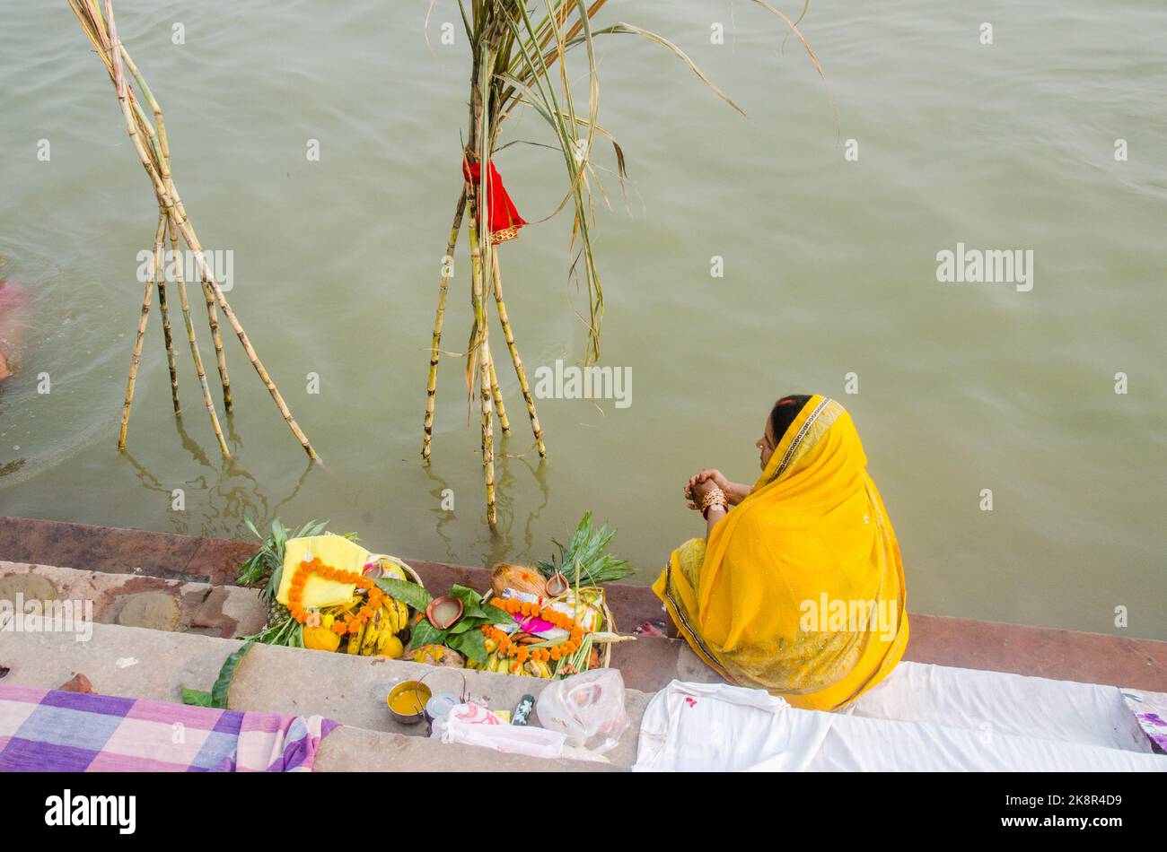Des hommes et des femmes indiens non identifiés prient et consacrent pour le festival Chhath Puja sur le côté du fleuve Ganges à Varanasi, Inde. Banque D'Images