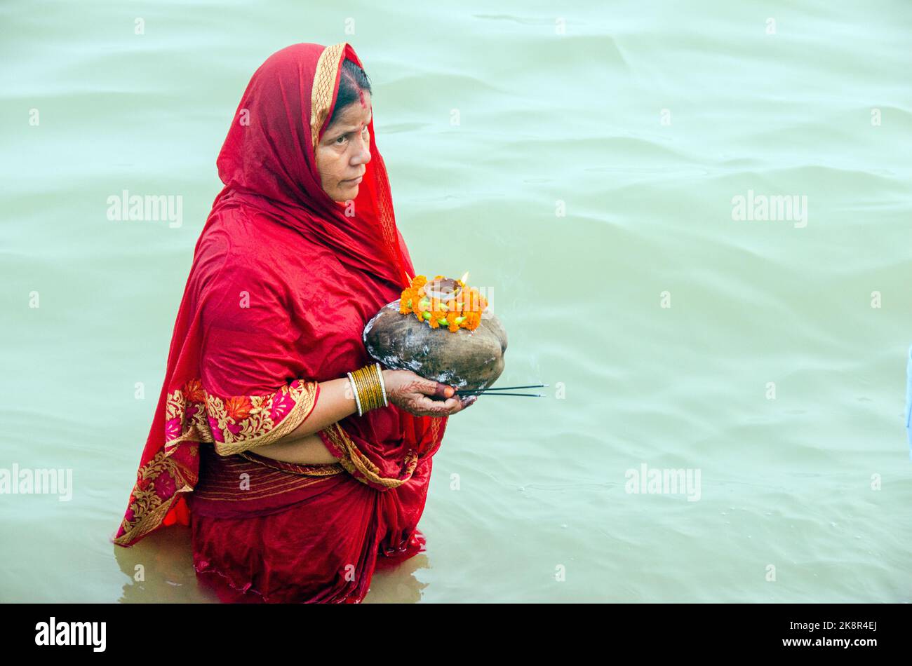 Des hommes et des femmes indiens non identifiés prient et consacrent pour le festival Chhath Puja sur le côté du fleuve Ganges à Varanasi, Inde. Banque D'Images