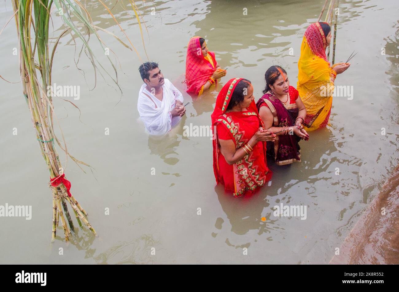 Des hommes et des femmes indiens non identifiés prient et consacrent pour le festival Chhath Puja sur le côté du fleuve Ganges à Varanasi, Inde. Banque D'Images