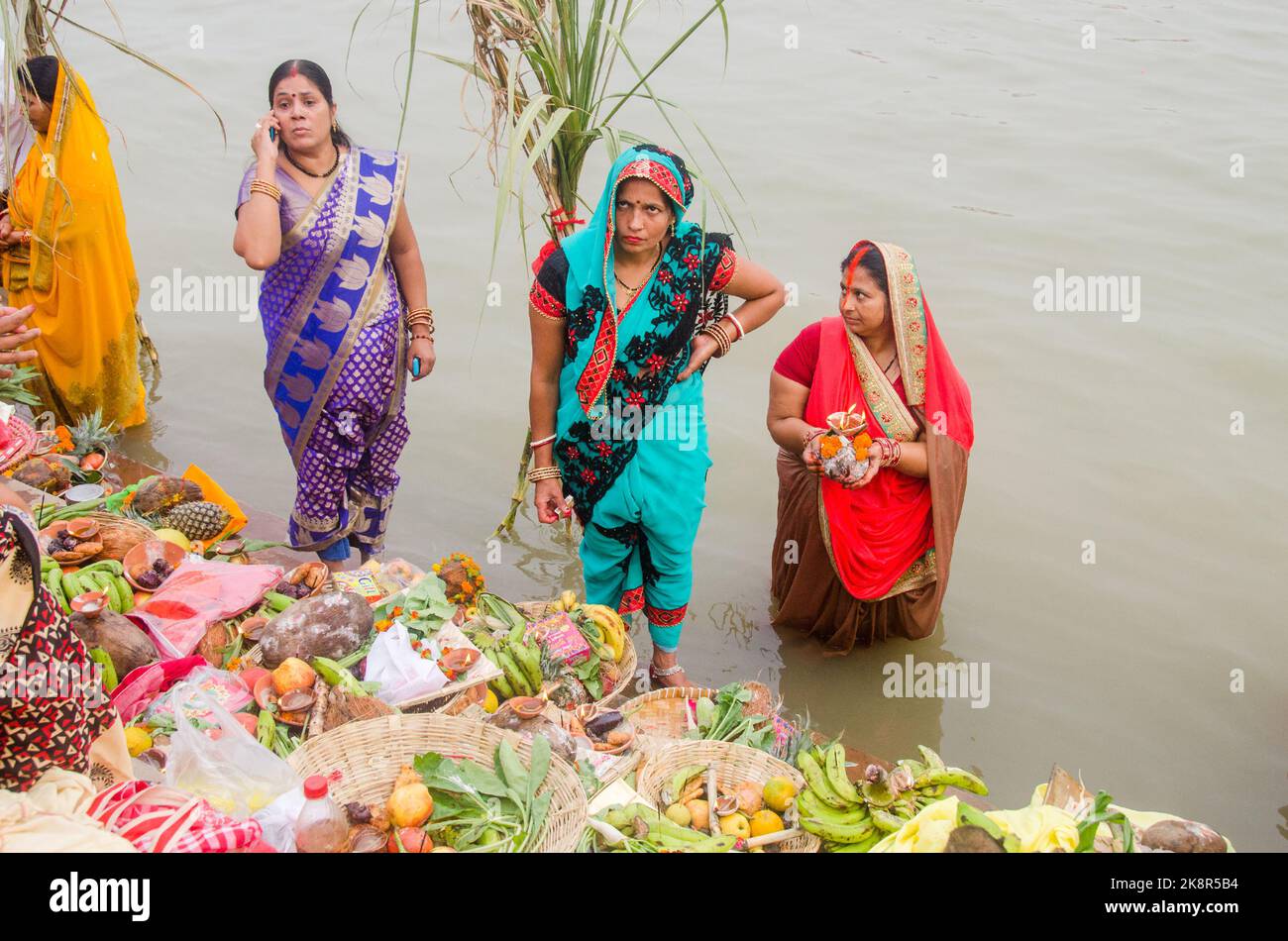 Des hommes et des femmes indiens non identifiés prient et consacrent pour le festival Chhath Puja sur le côté du fleuve Ganges à Varanasi, Inde. Banque D'Images