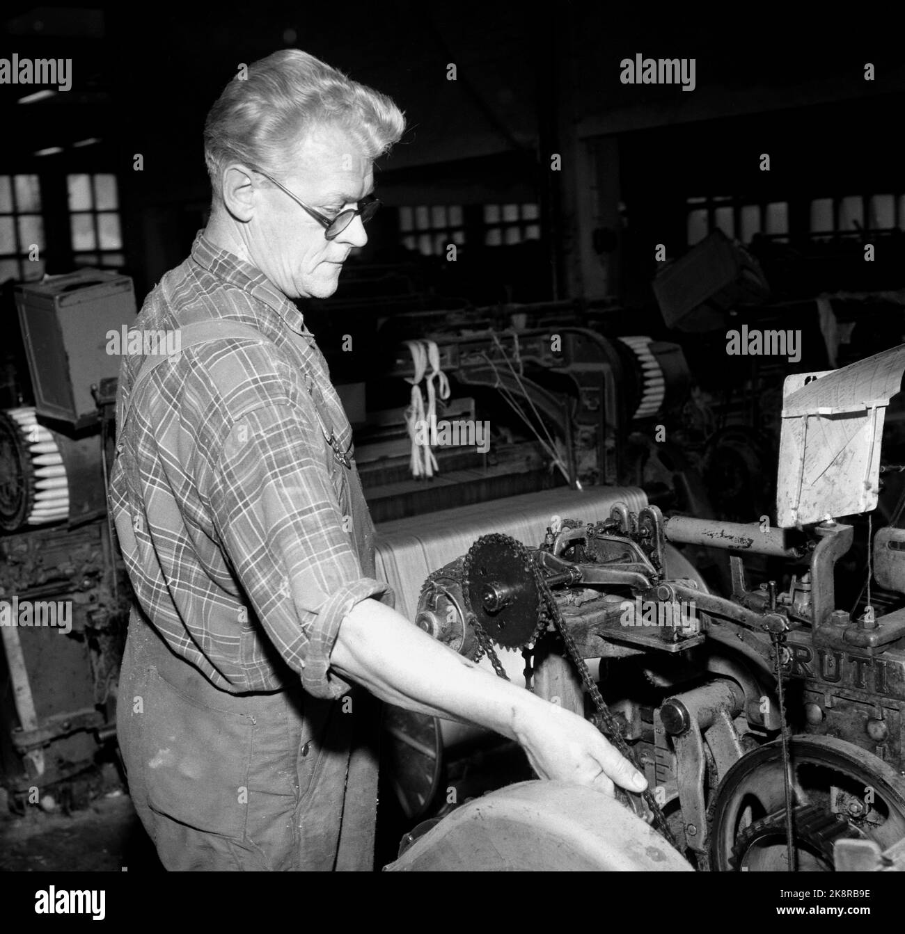 Oslo 195710. Les roues Veveri A/S doivent être réglées en raison de difficultés financières. L'entreprise a plus de 100 ans, le tissage le plus moderne de Scandinavie, et l'un des plus anciens magiciens du coton du pays, avec 350 employés, beaucoup de professionnels sont des personnes plus âgées. L'image provient du hall de production. Henry mentent au travail dans le hall de production. Il est l'un des professionnels avec un long temps dans l'entreprise. Photo Aage Storløkken / actuel / NTB Banque D'Images