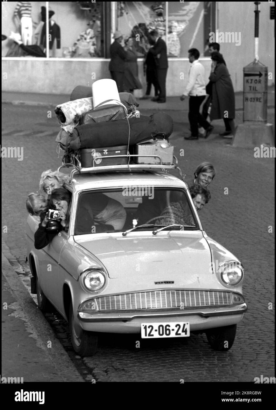 Été juillet 1960. Vacances en voiture. Deux femmes et trois enfants en vacances en voiture - la marque Anglia. Les bagages sont chargés sur le toit. Les mères et les enfants collent leur tête hors de la fenêtre de la voiture. Famille en vacances sous tente. Photo: Aage Storløkken / actuel / NTB Banque D'Images