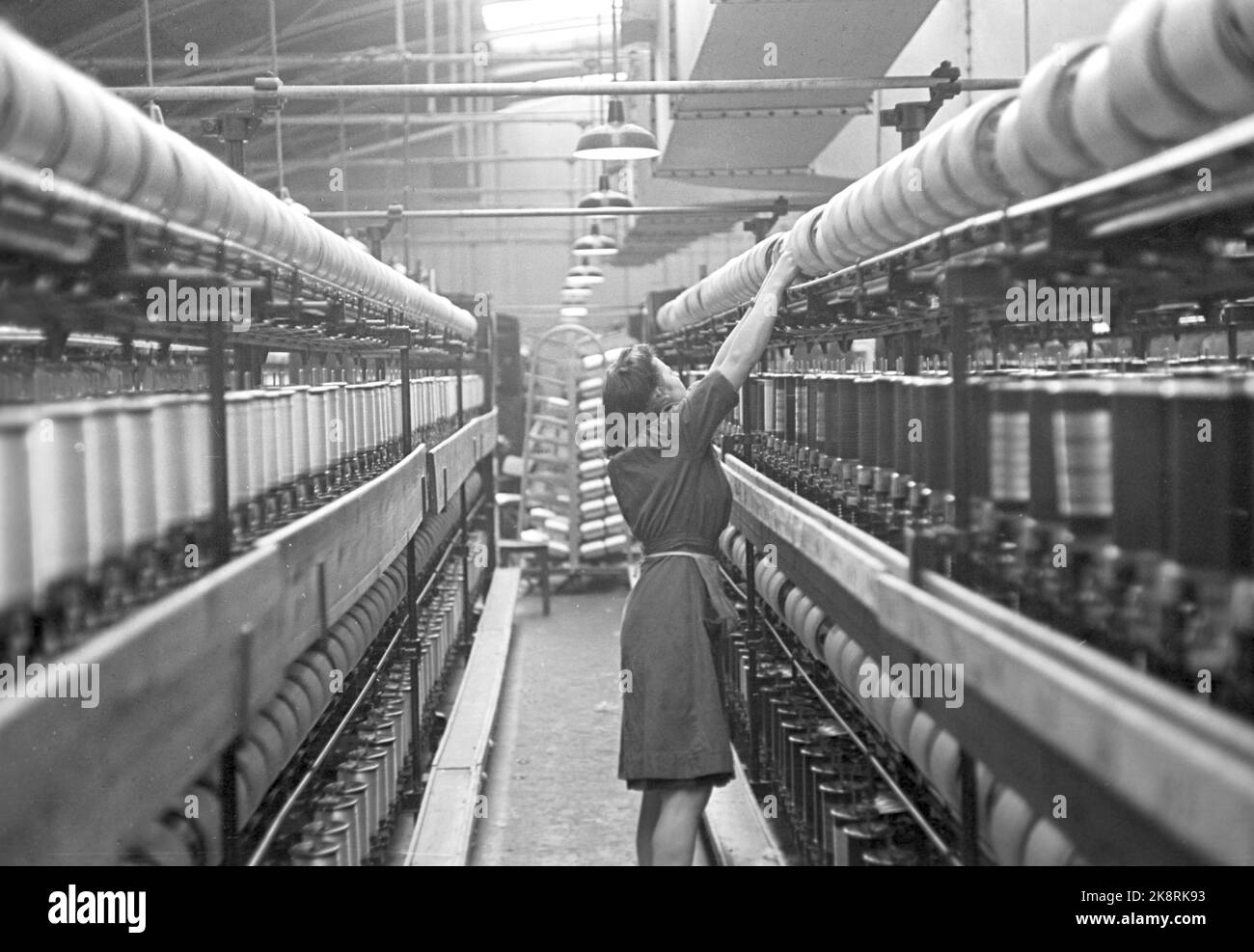 Notodden 19490312 Kunstsilkefabrikken COMME production de soie d'Art. -Dans les émacines de torsion, le fil est tordu pour fournir la force. La vitesse des bobines est de 5000 pr. Minute, et bien sûr, il arrive que le fil éclate pendant cette vitesse. Photo; Sverre A. Børretzen / courant / NTB Physical LOC. Actuel n° 6 1949 Knittering Sliilk du ministère des forêts Banque D'Images