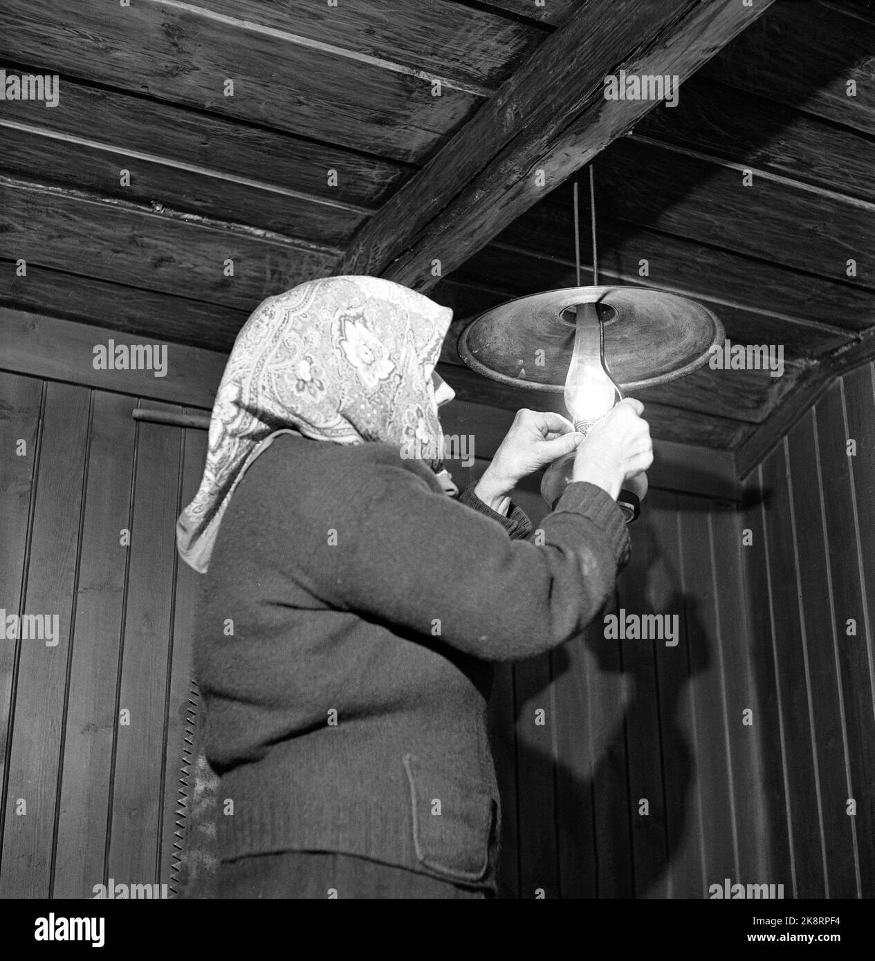 Dalen dans Telemark, février 1955. Ingerine et Gurine Schvenius (83 et 81 ans) vivent seuls dans la région du Roi carré ou Rui dans la vallée du Telemark. Le temps est resté dans cette petite place haute dans le monde de montagne. Ici, la lampe à paraffine Ingerine s'allume. Photo: Aage Storløkken / actuel / NTB Banque D'Images