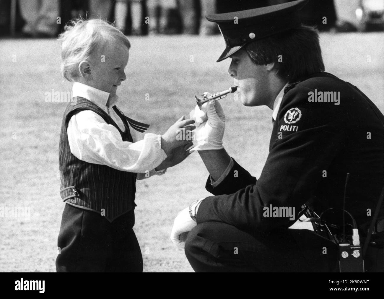 Oslo 19810517 : 17 mai à Oslo. 17 mai est la journée des enfants. Ici, 'Oncle police' emprunter la trompette pour un petit garçon. Photo: NTB / NTB Banque D'Images