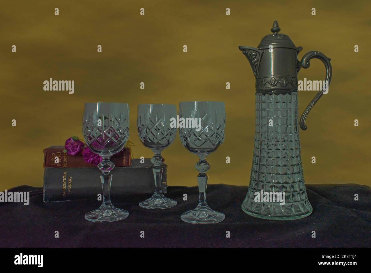 Still Life-trois verres à vin vintage, des bibles et une cruche à vin recouverte d'argent avec un fond or foncé Banque D'Images
