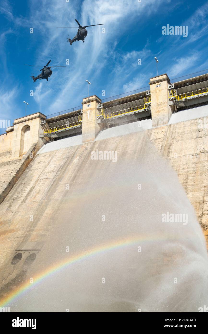 Hélicoptères militaires survolant le mur du barrage hydroélectrique. Concept/image composite. Ukraine, Russie, guerre, centrale électrique, russe, énergie, crime de guerre... Banque D'Images