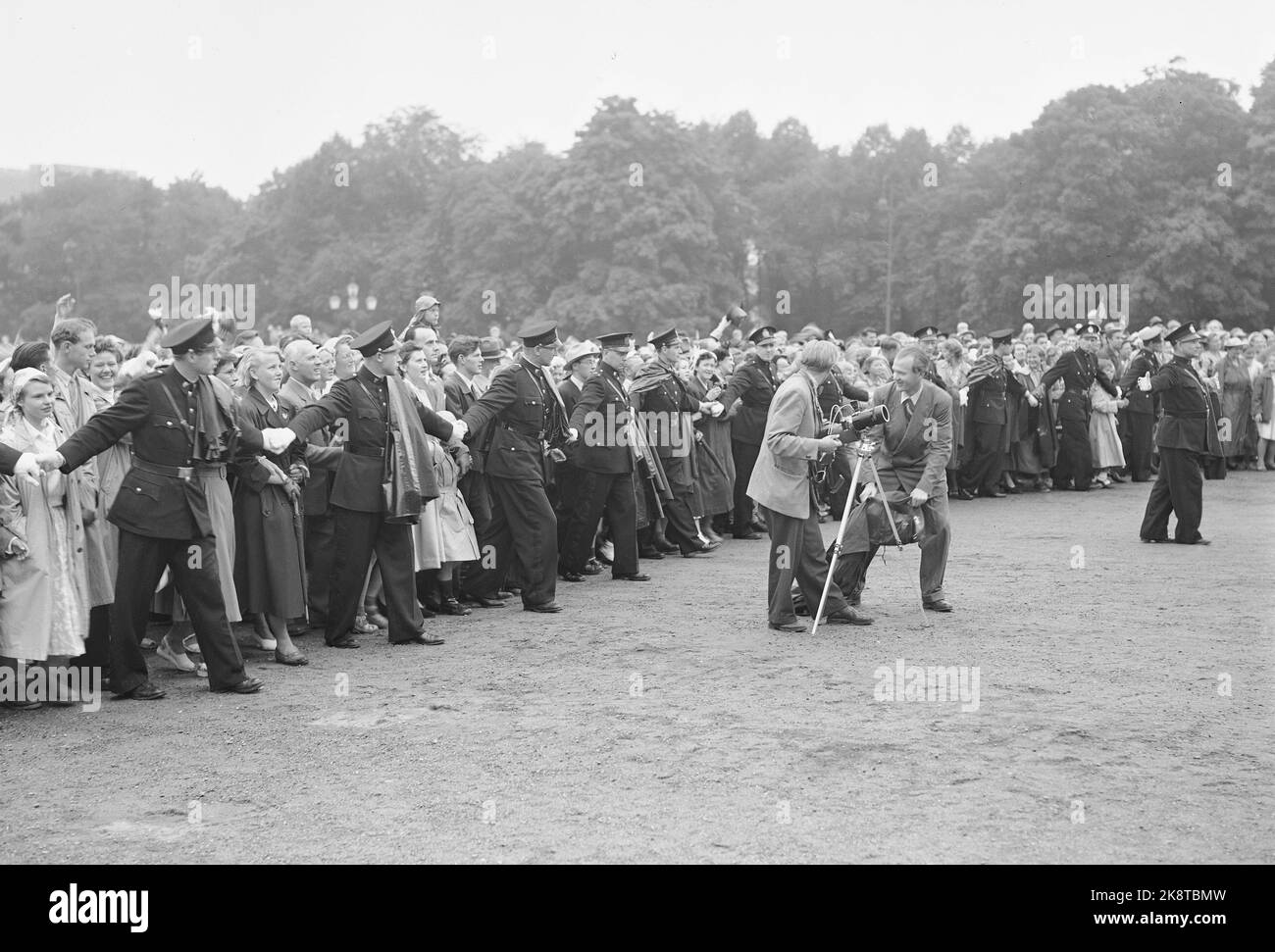 Oslo 19520803. Roi Haakon 80 ans 3 août 1952. C'est ce à quoi ressemblait Slottsplassen après que le roi est revenu de son tour à Oslo City. Derrière une chaîne d'officiers de police, la masse se dit vers le haut alors que tout le monde applaudit au roi. Malgré le fait qu'il a probablement été trempé après la conduite sous la pluie, le roi est sorti sur le balcon et a reçu l'hommage. PHOTO: VALLDAL NTB / NTB Banque D'Images