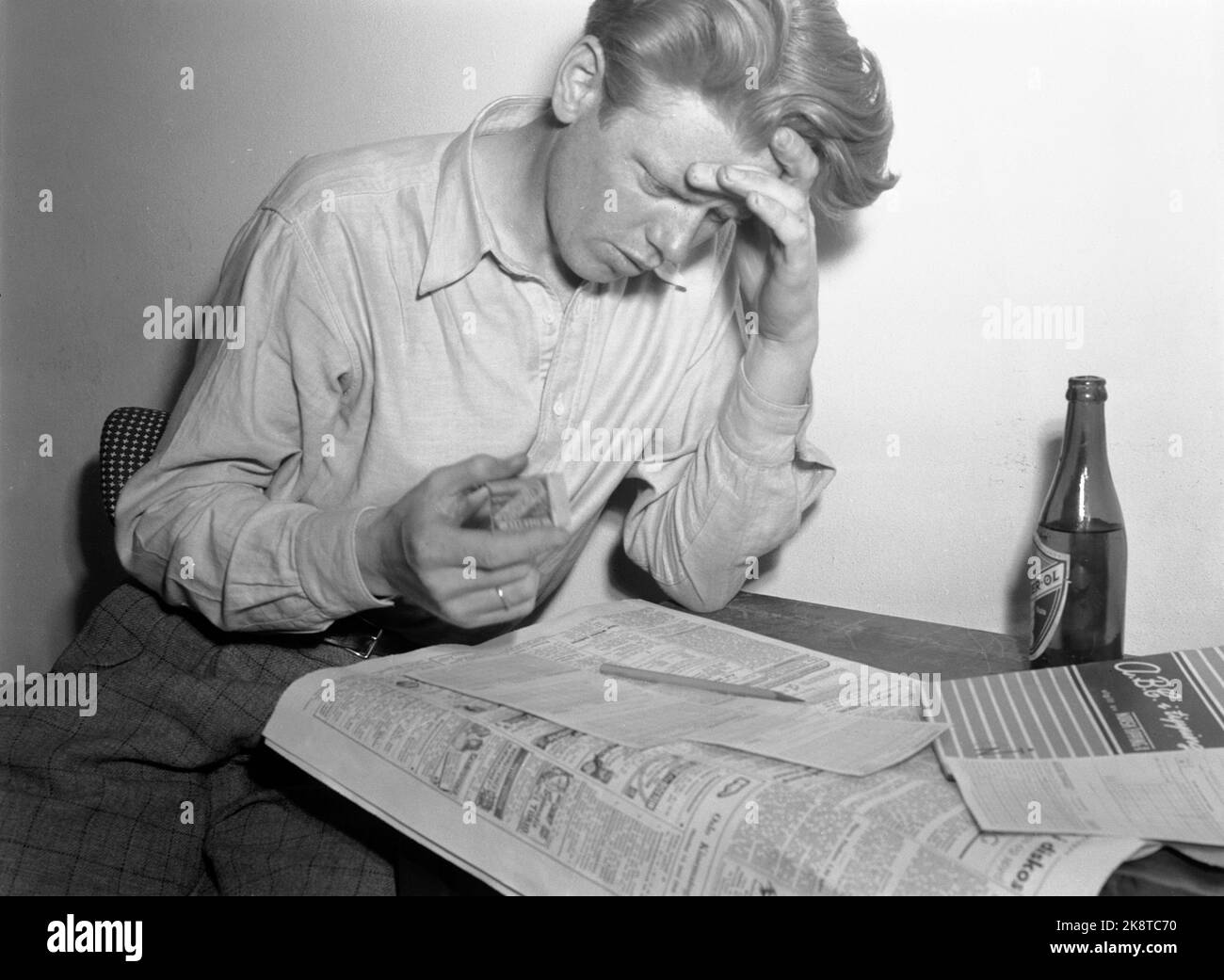 Oslo juillet 1948. Norsk Tipping commence ses affaires avec le football de basculement dans toute la Norvège. Voici un conseil enthousiaste qui étudie les résultats du football dans le journal avec une bière et une cigarette avant de faire ses choix, tandis que d'autres laissent l'aléatoire prévaloir. Remplissage du coupon de pourboires. Photo: Actuel / NTB Banque D'Images