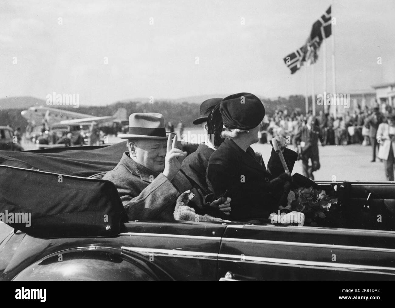 Oslo 19480512. Le Premier ministre britannique Winston Churchill se rend en Norvège. Churchill et sa femme ont été accueillis par le roi Haakon à l'aéroport de Fornebu. Le voyage au château de Fornebu a été un train de triomphe. Des foules jubilantes sur les trottoirs pour apercevoir les clients. En photo, la princesse Märtha, le roi Haakon et Churchill montrant le V-sign. Photo: NTB Banque D'Images