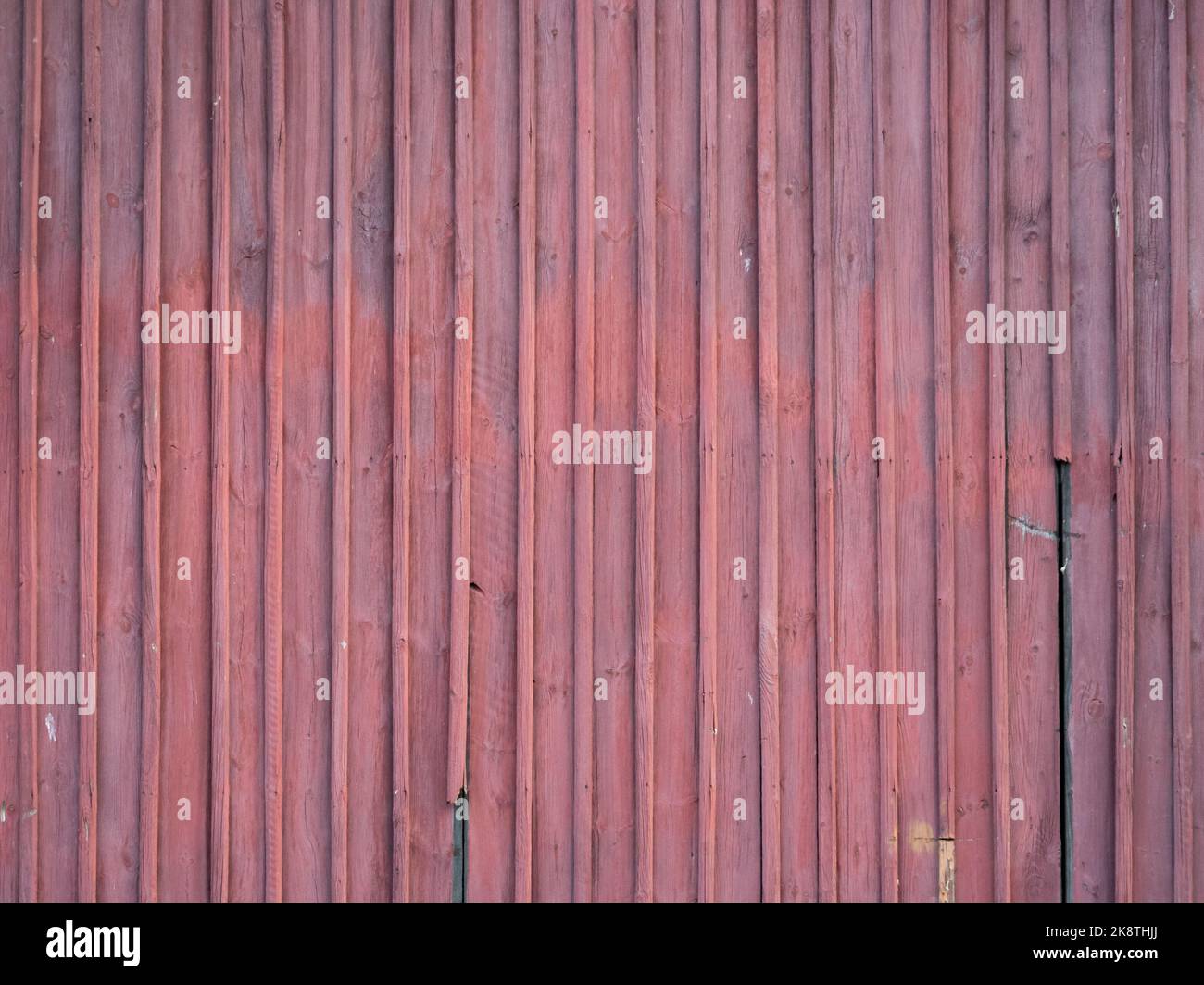 Arrière-plan de planches en bois rouge. Panneaux partiellement cassés et abîmés. Texture d'un bâtiment extérieur d'une vieille maison. Motif de conception vertical. Banque D'Images